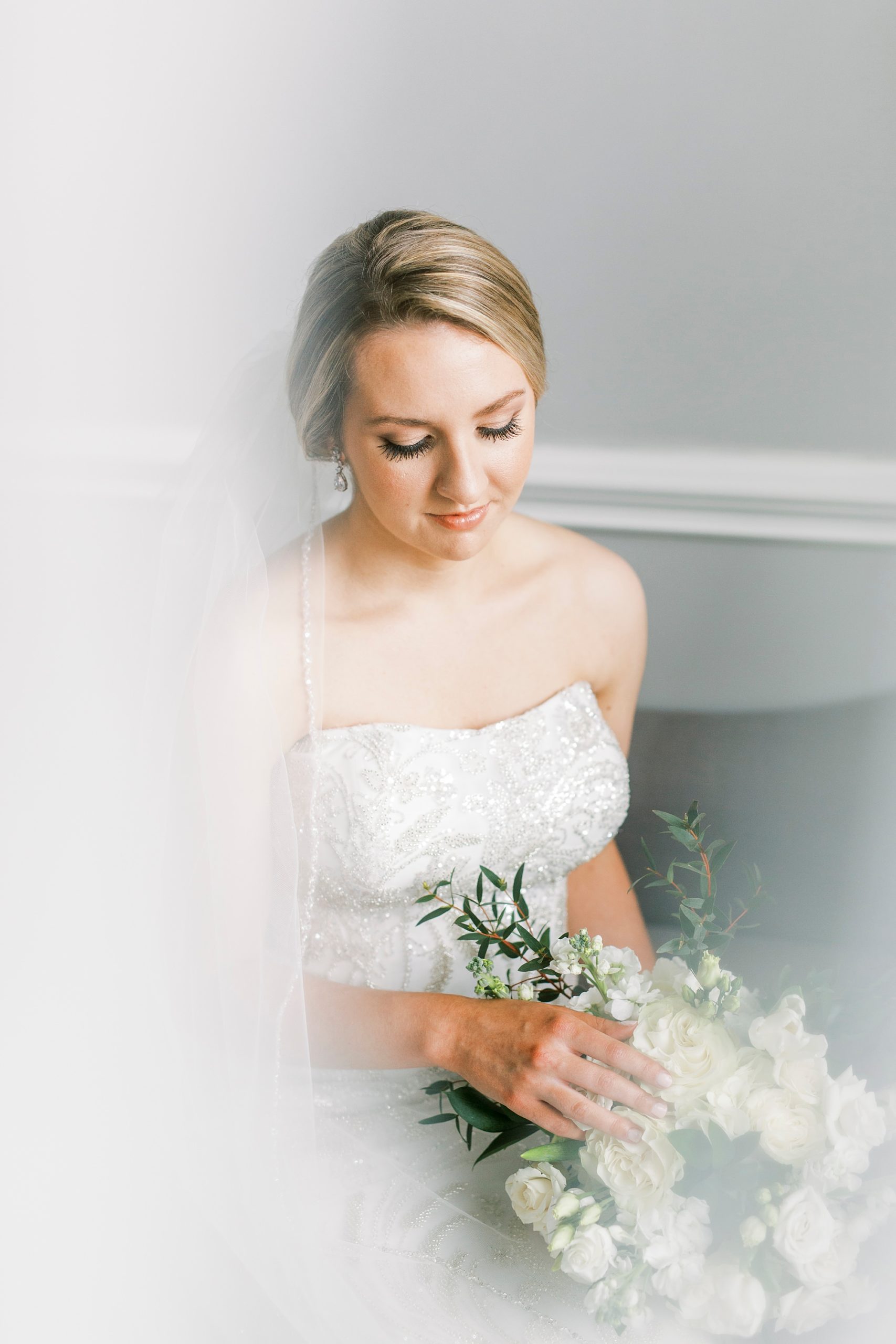 bride holds bouquet looking down at it at Separk Mansion