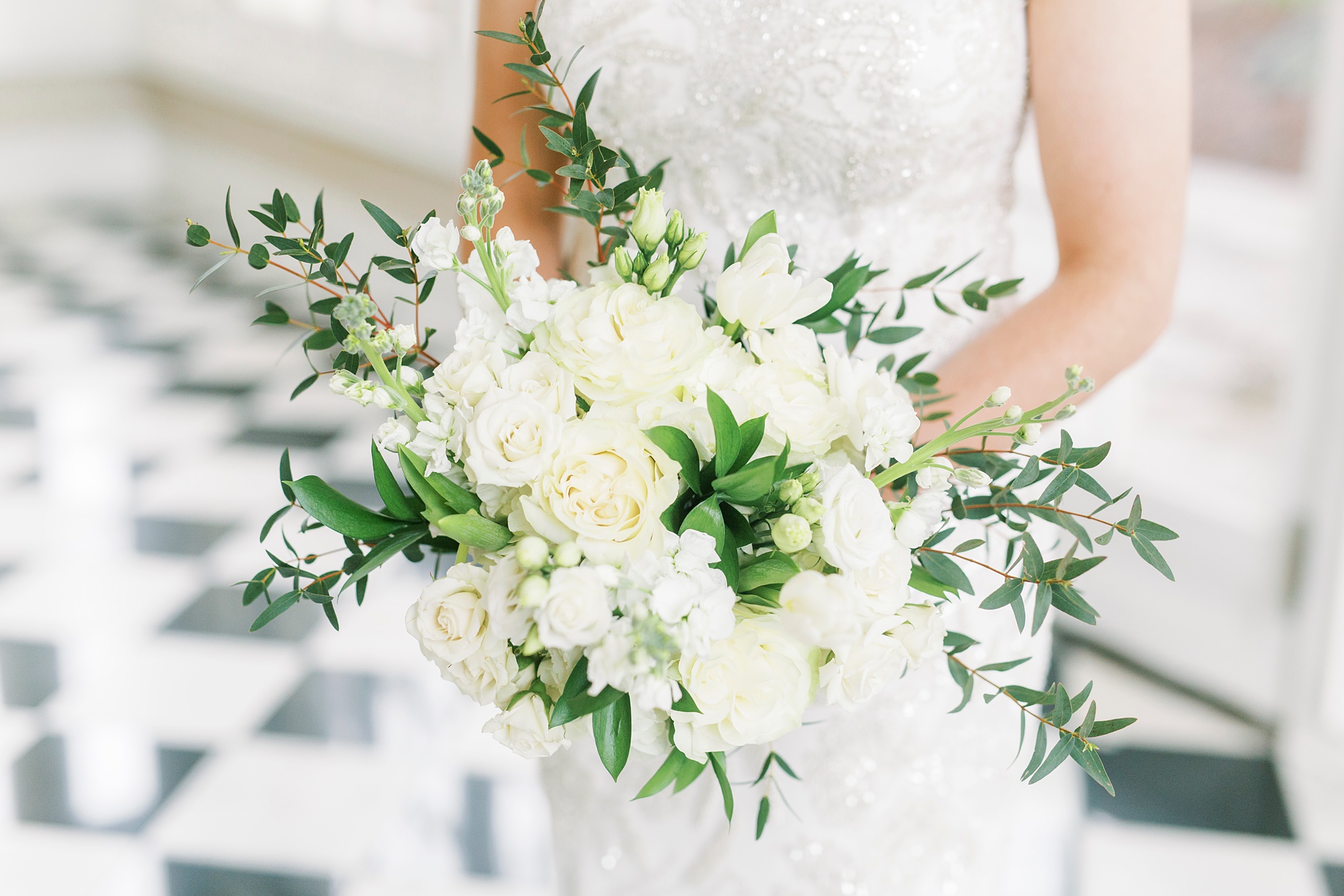 bride holds bouquet of white flowers