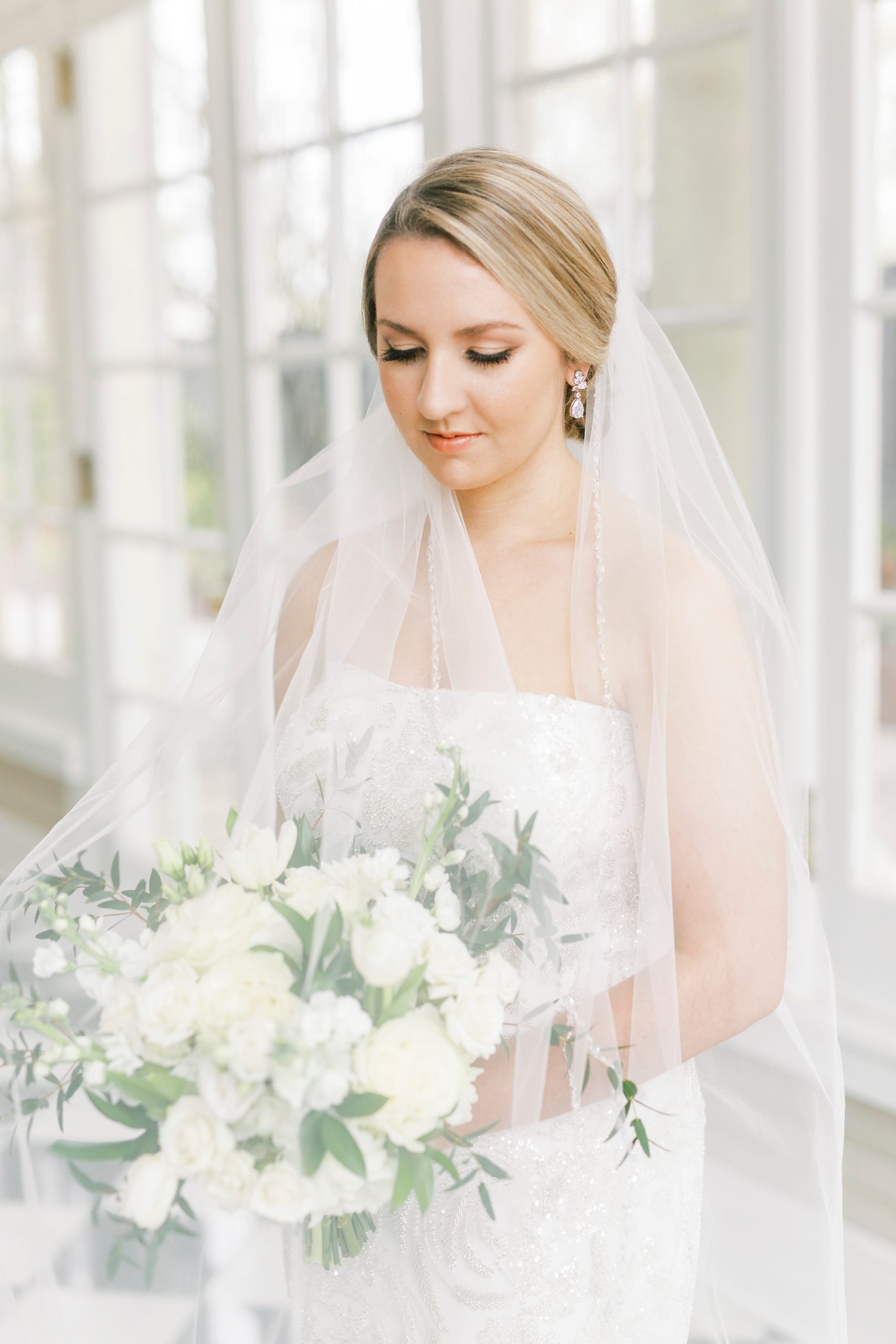 bride holds bouquet under veil during NC bridal session
