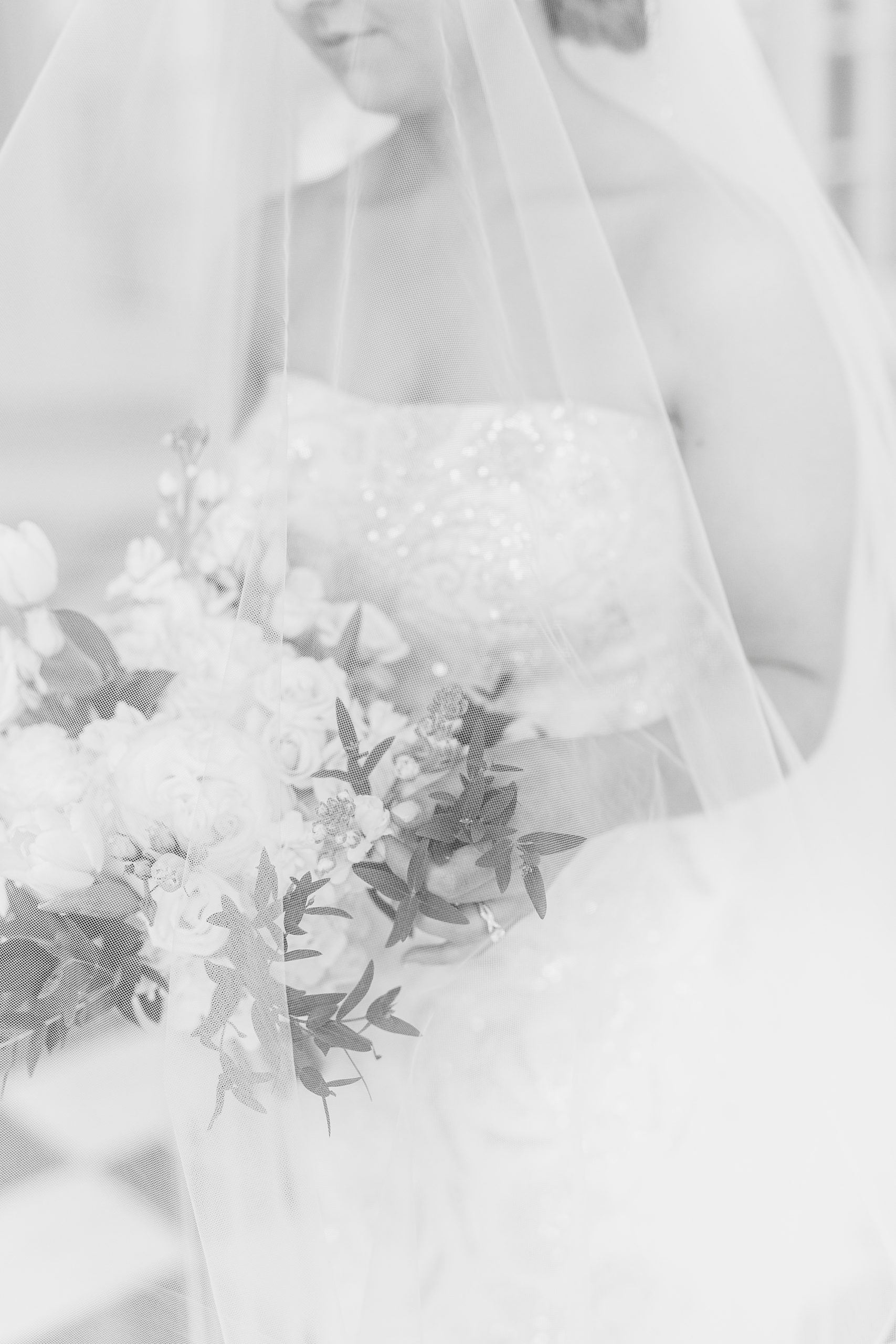 bride holds bouquet of flowers under veil in NC