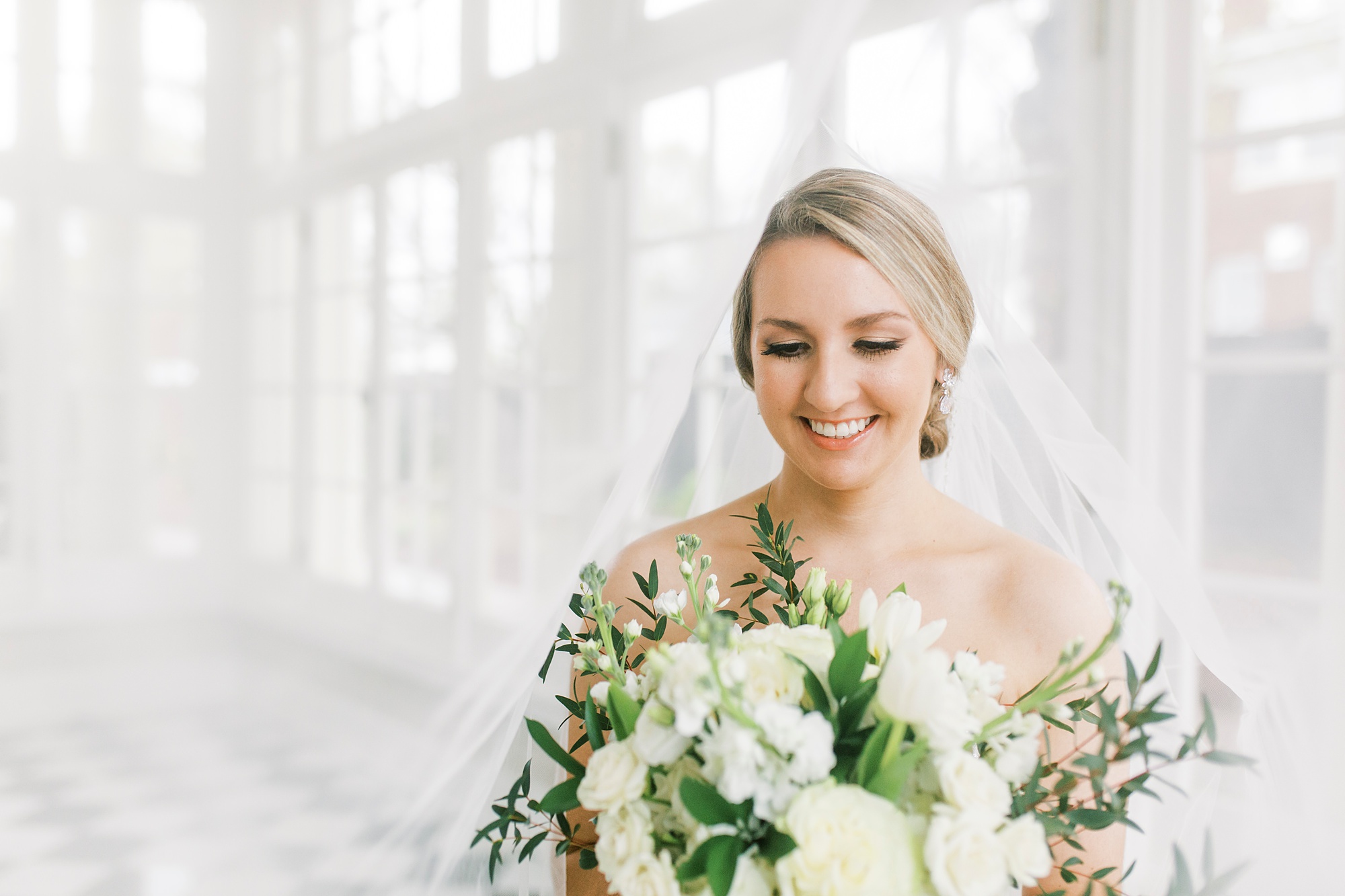 bride looks down at ivory bouquet during Separk Mansion bridal session