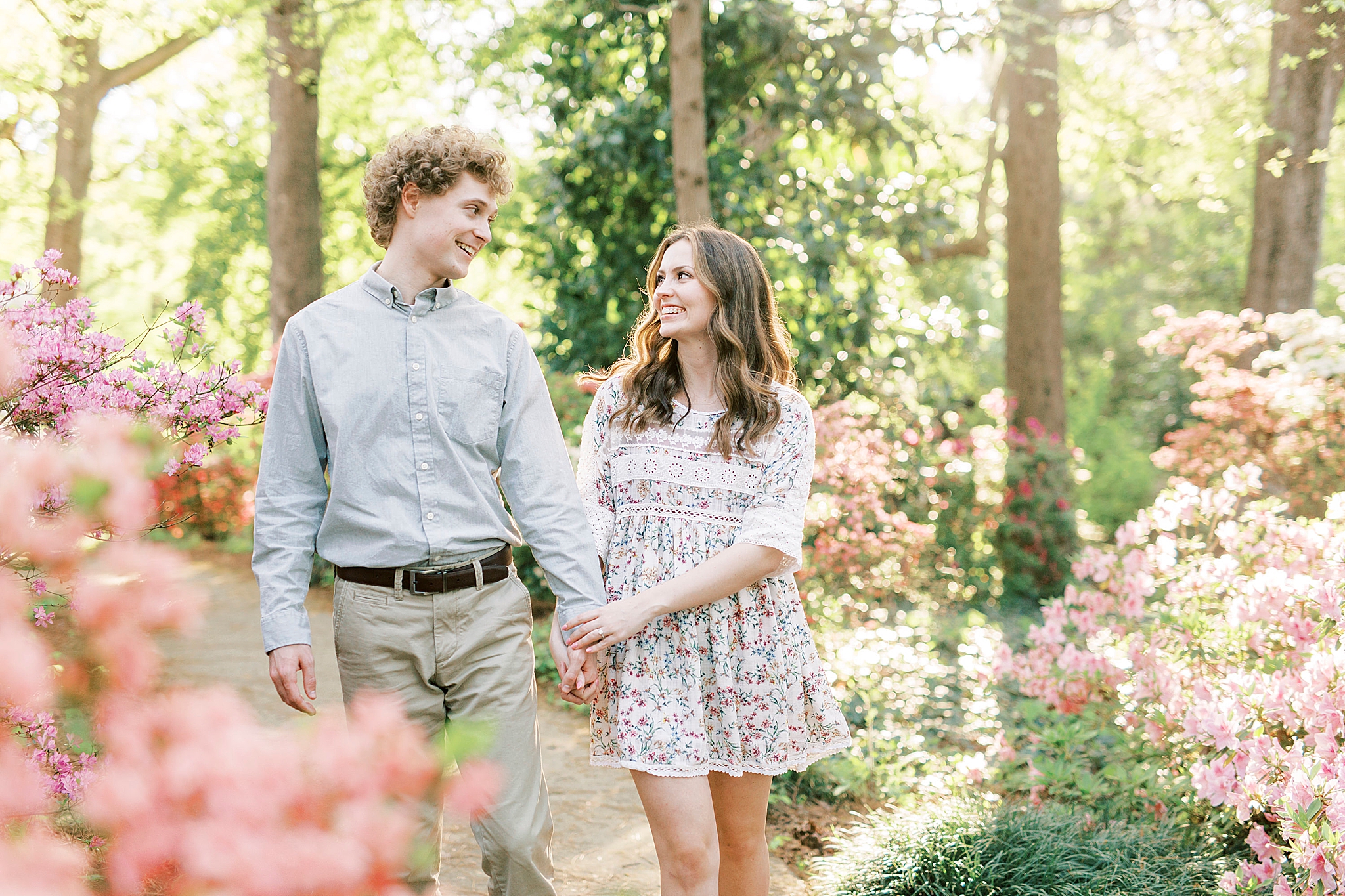 couple walks through woods in Glencairn Gardens in Rockhill SC