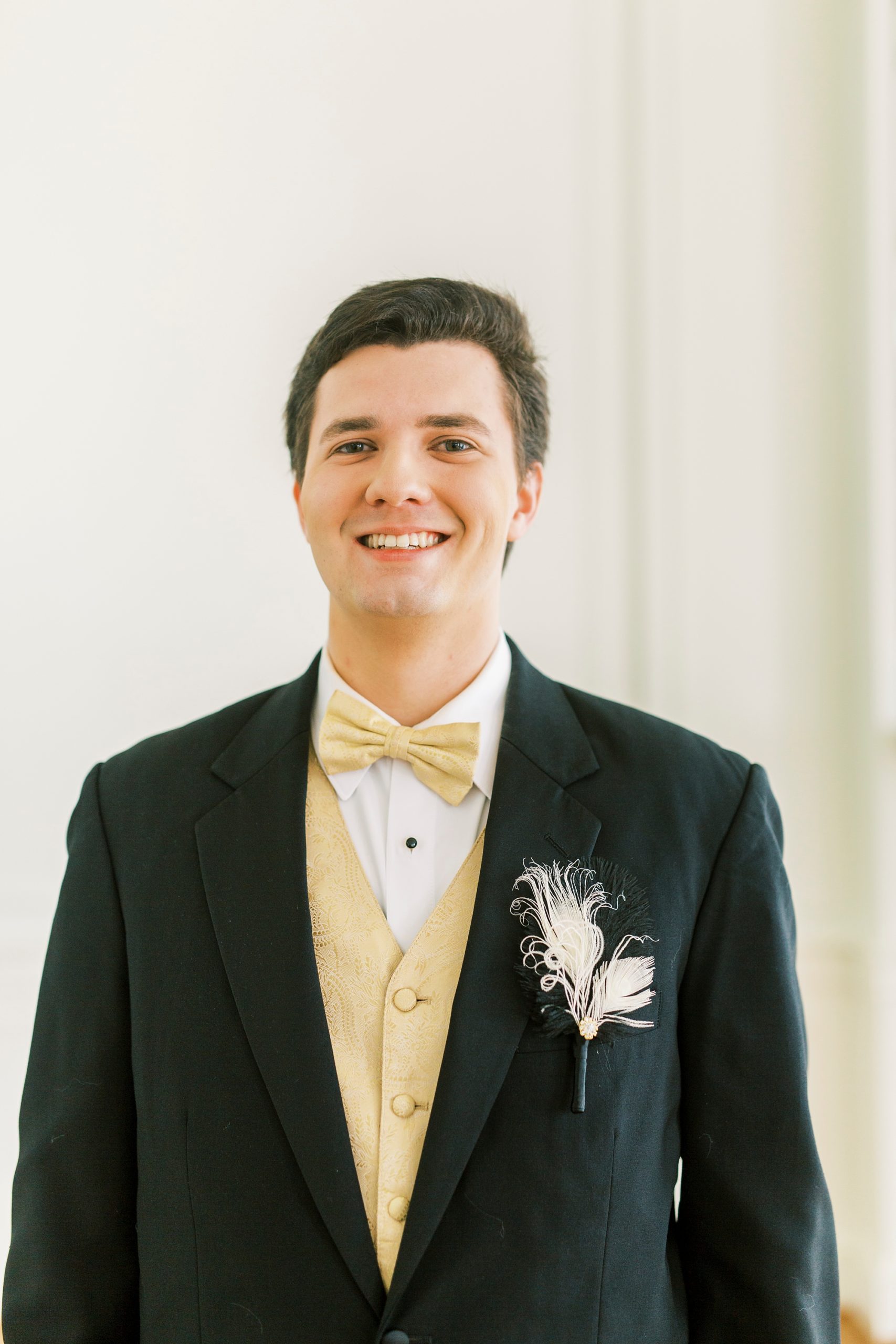 birthday boy in suit with yellow vest poses before Great Gatsby birthday party