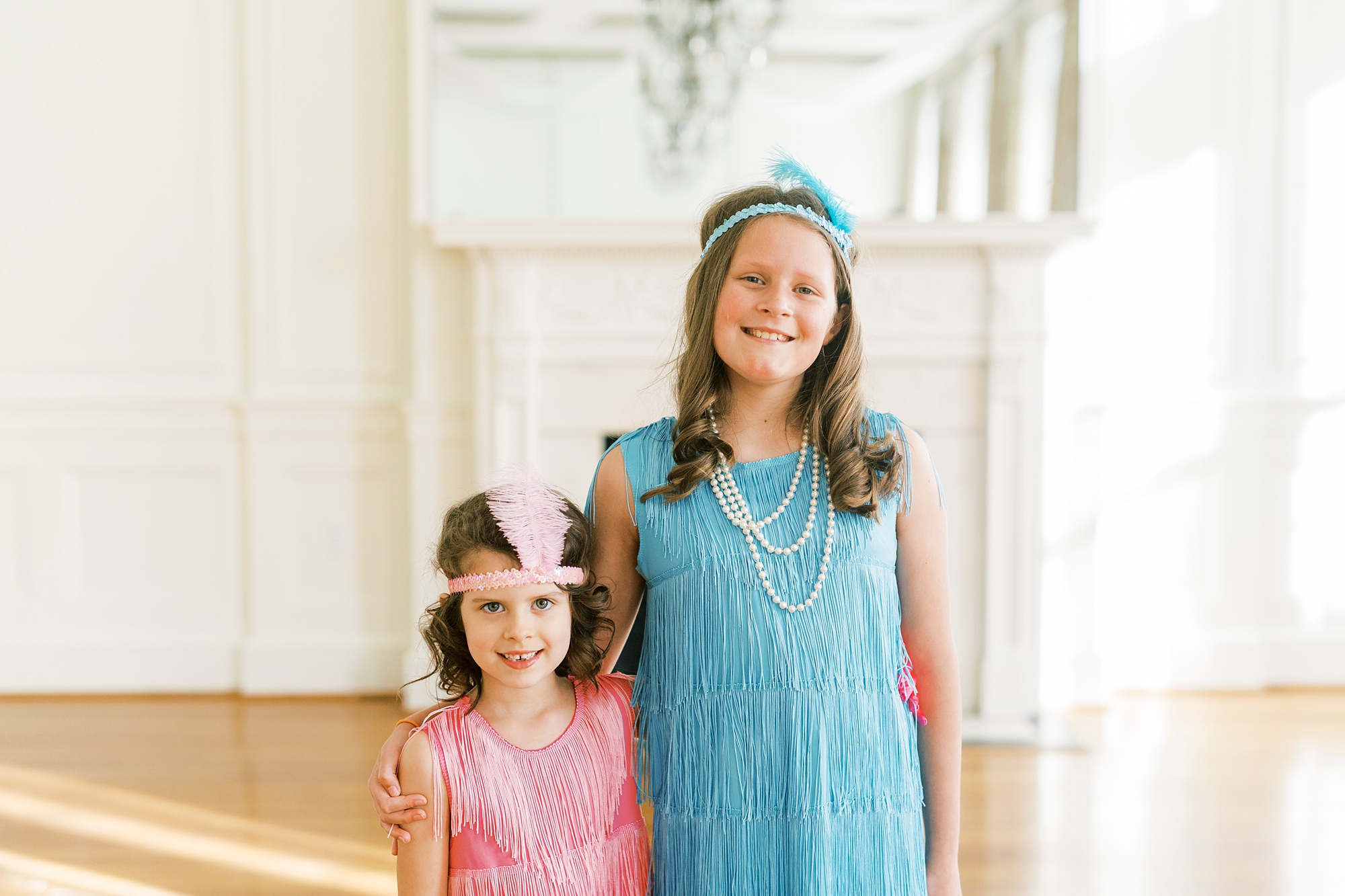 girls pose together in colorful dresses for birthday party