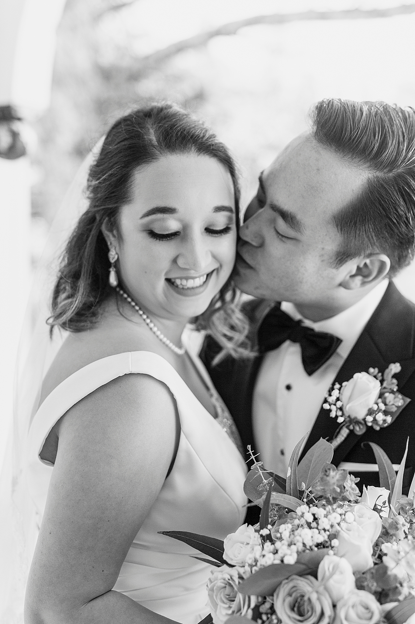 groom kisses bride's cheek during first look