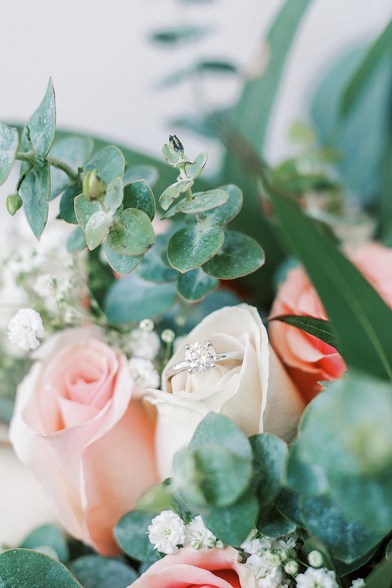 wedding bouquet with diamond ring on ivory rose