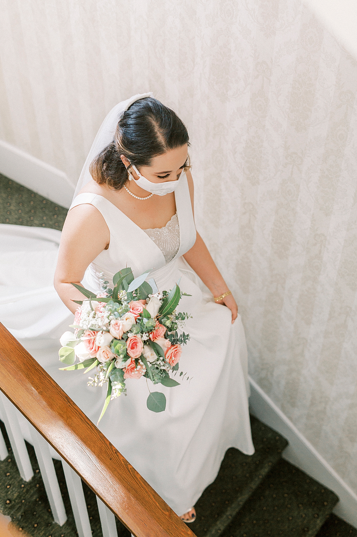 bride walks down steps at Green Park Inn with mask