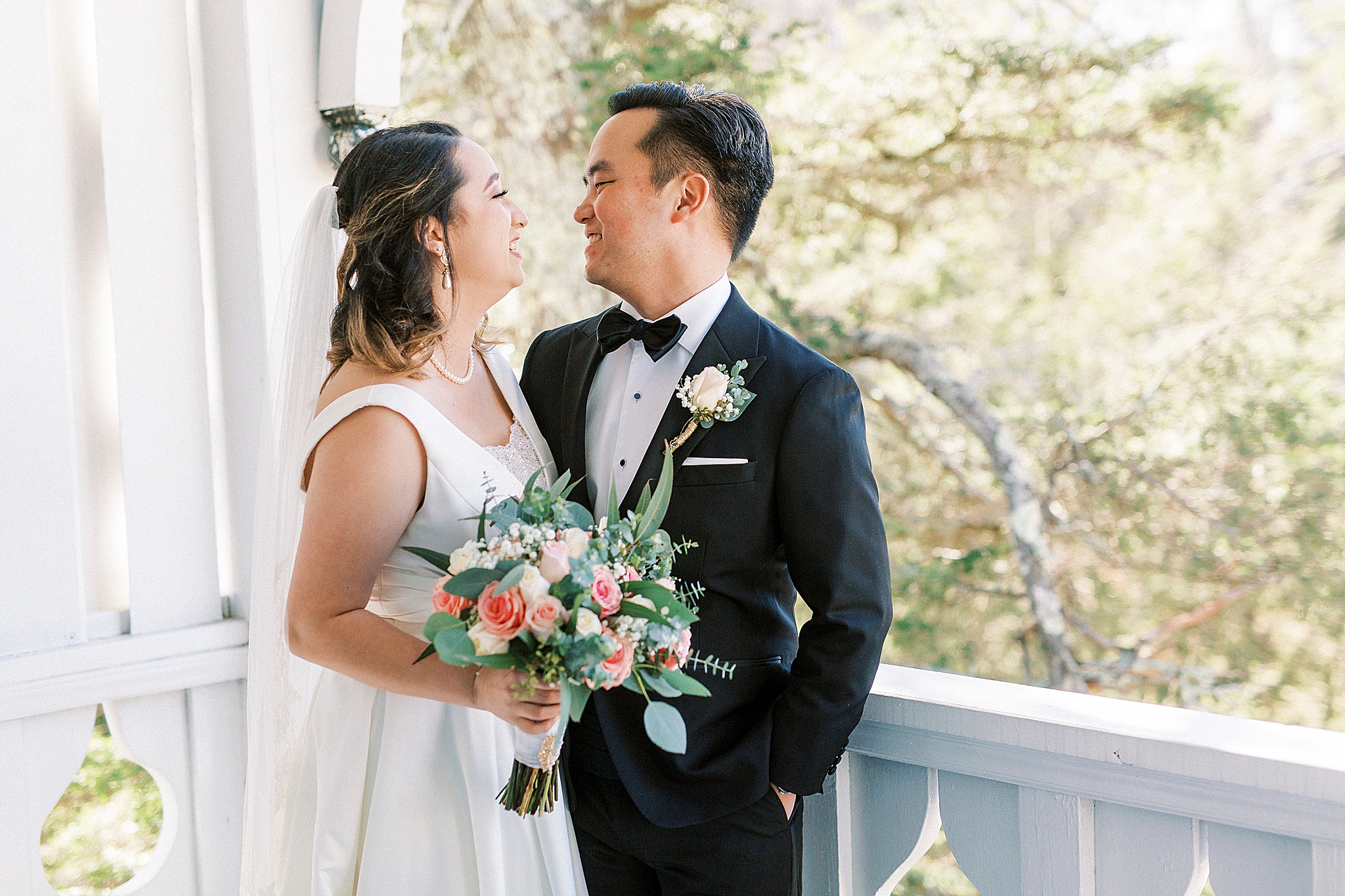 newlyweds look at each other on balcony