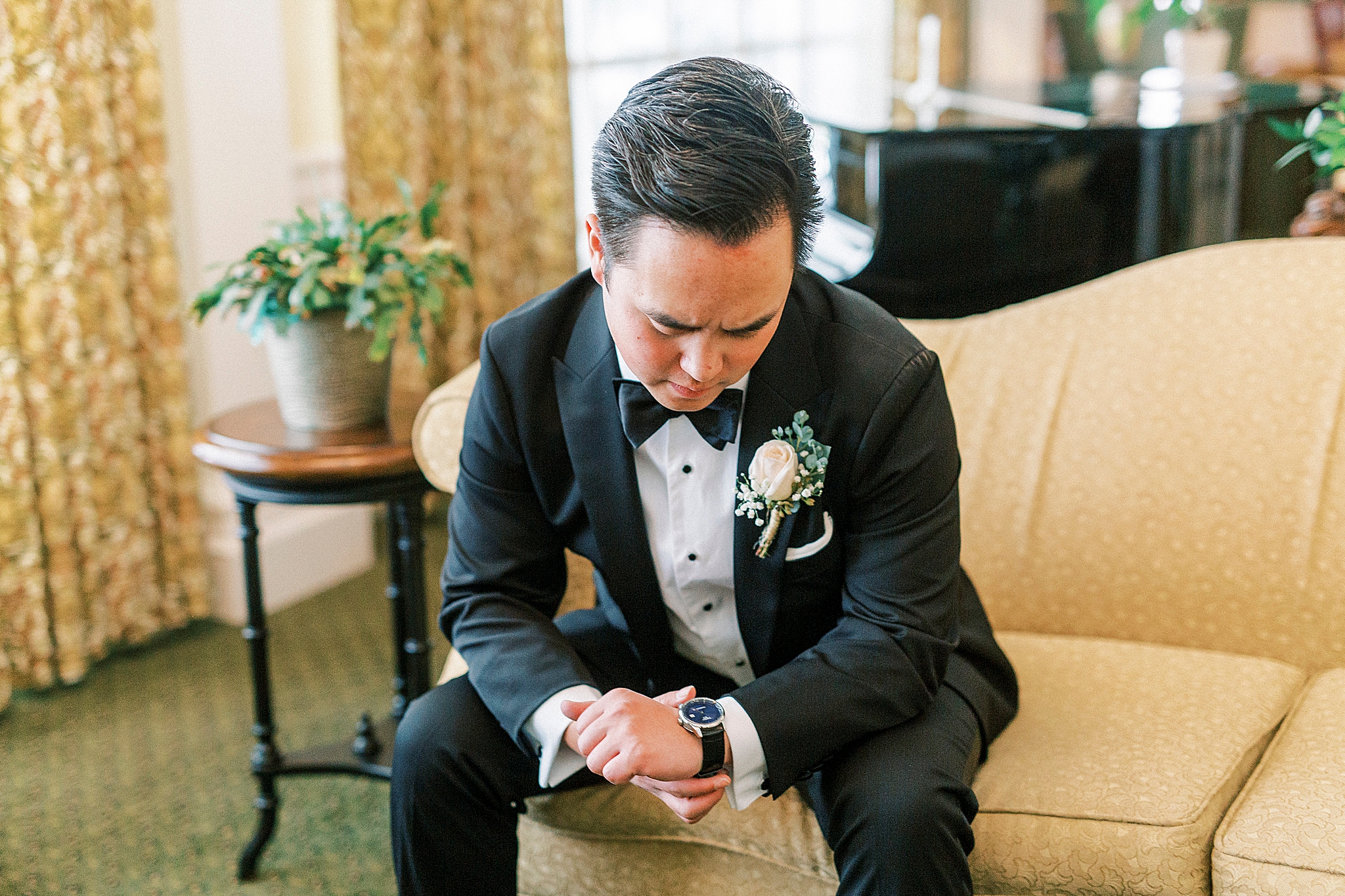 groom looks at watch during portraits in Green Park Inn