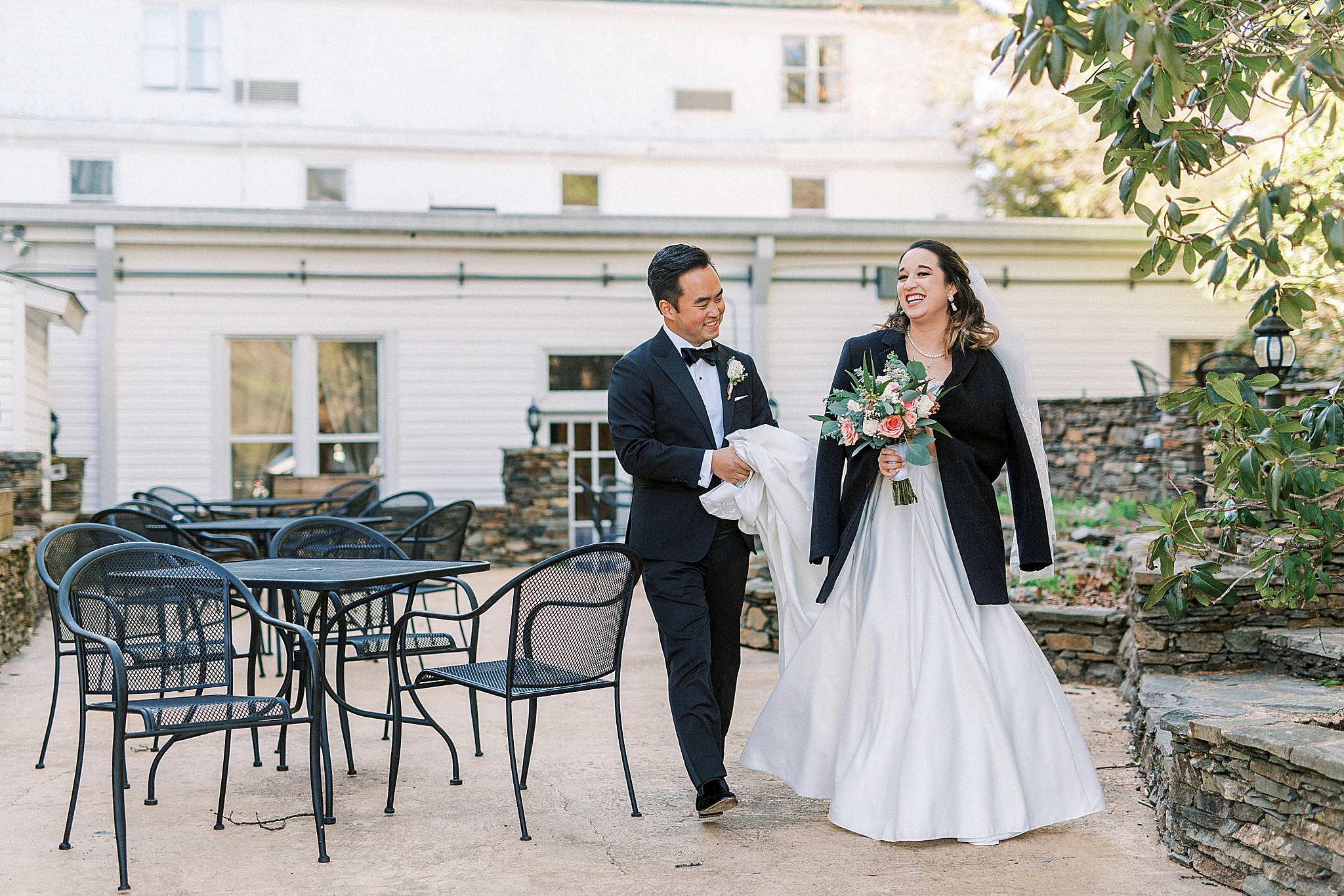 bride wears groom's jacket during wedding photos