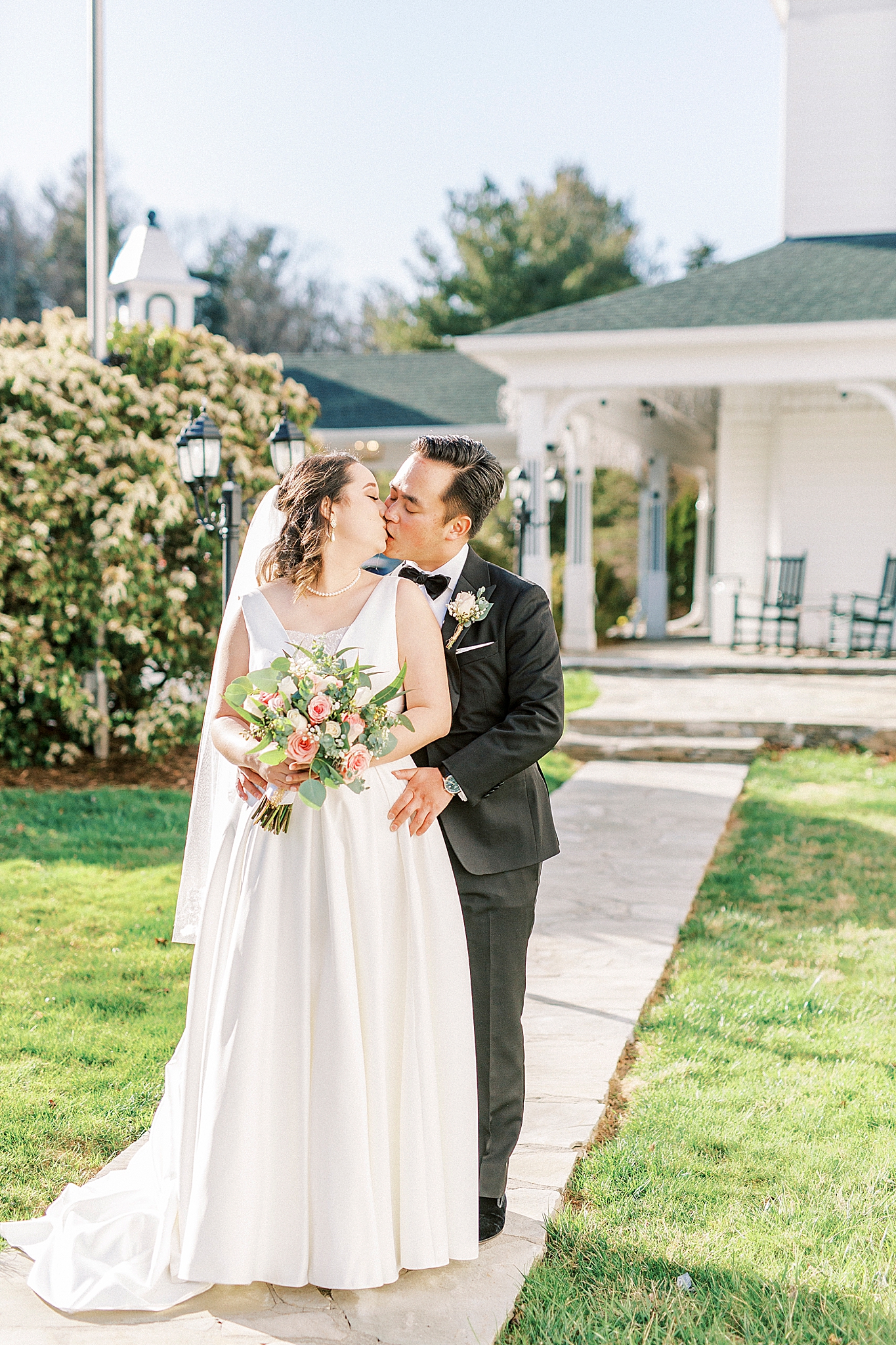 bride and groom pose on sidewalk during NC wedding day