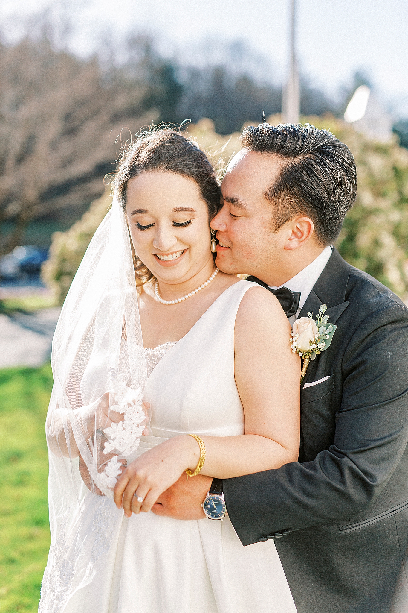 groom leans to kiss bride's cheek during NC wedding photos