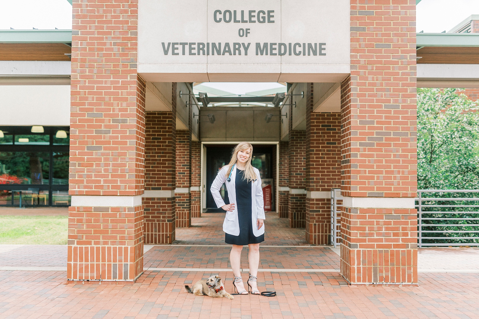 Vet school graduate poses outside NC State vet school building