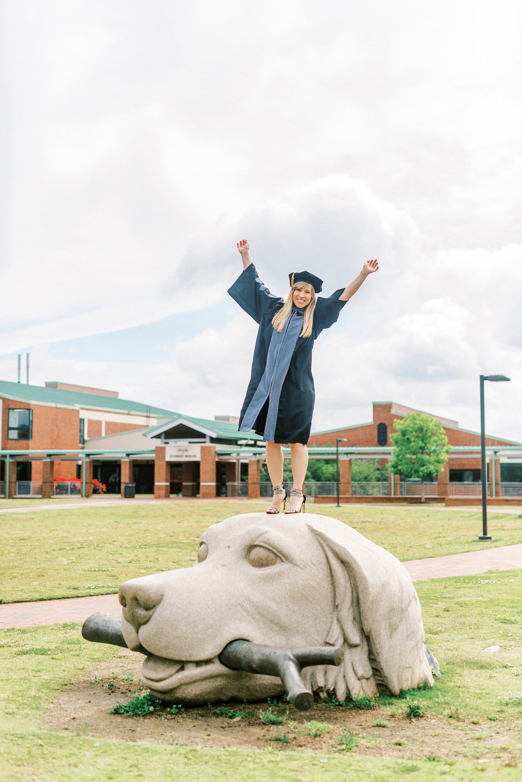 graduate stands on dog wearing cap and gown