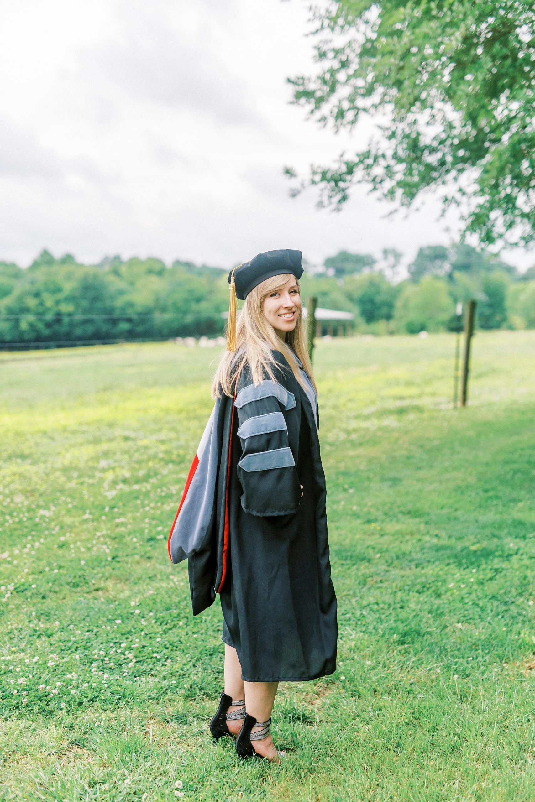 graduate looks over shoulder in cap and gown