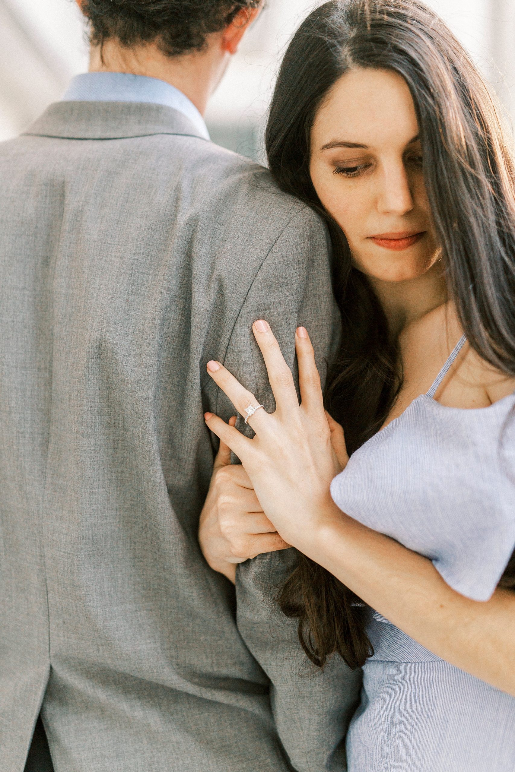 bride and groom lean against each other during Uptown Charlotte engagement session