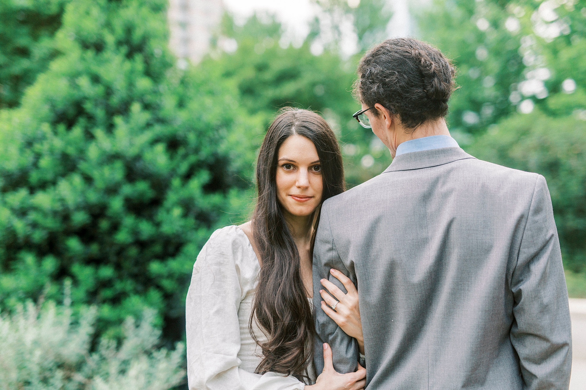 bride holds groom's arm looking over shoulder during NC photos