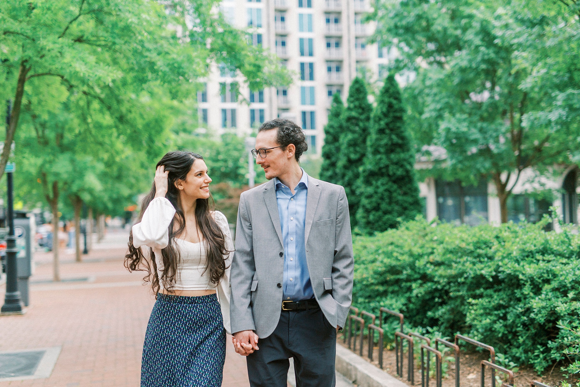 engaged couple walks through uptown Charlotte NC park