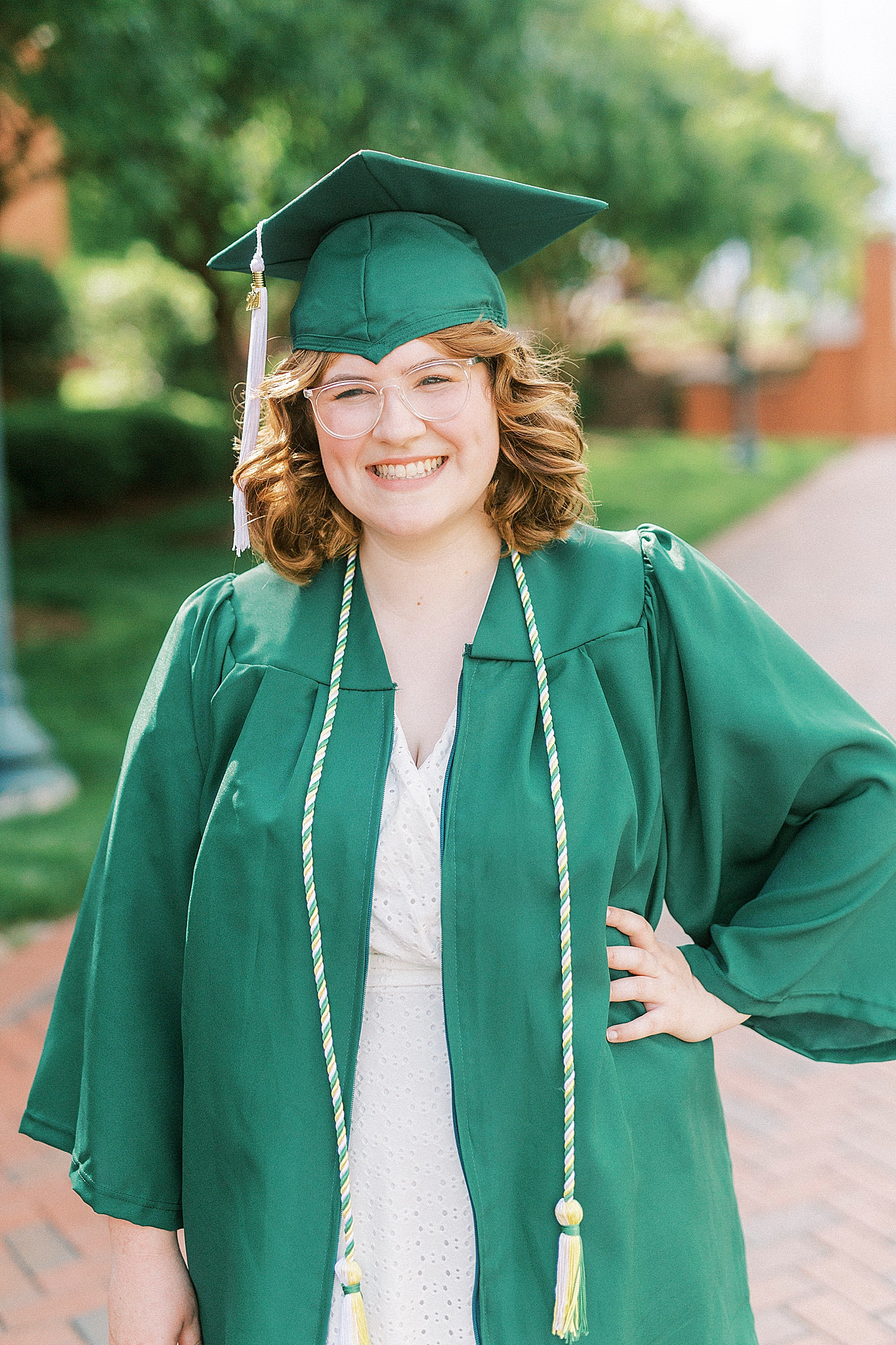 senior poses in green robe for UNCC senior pictures