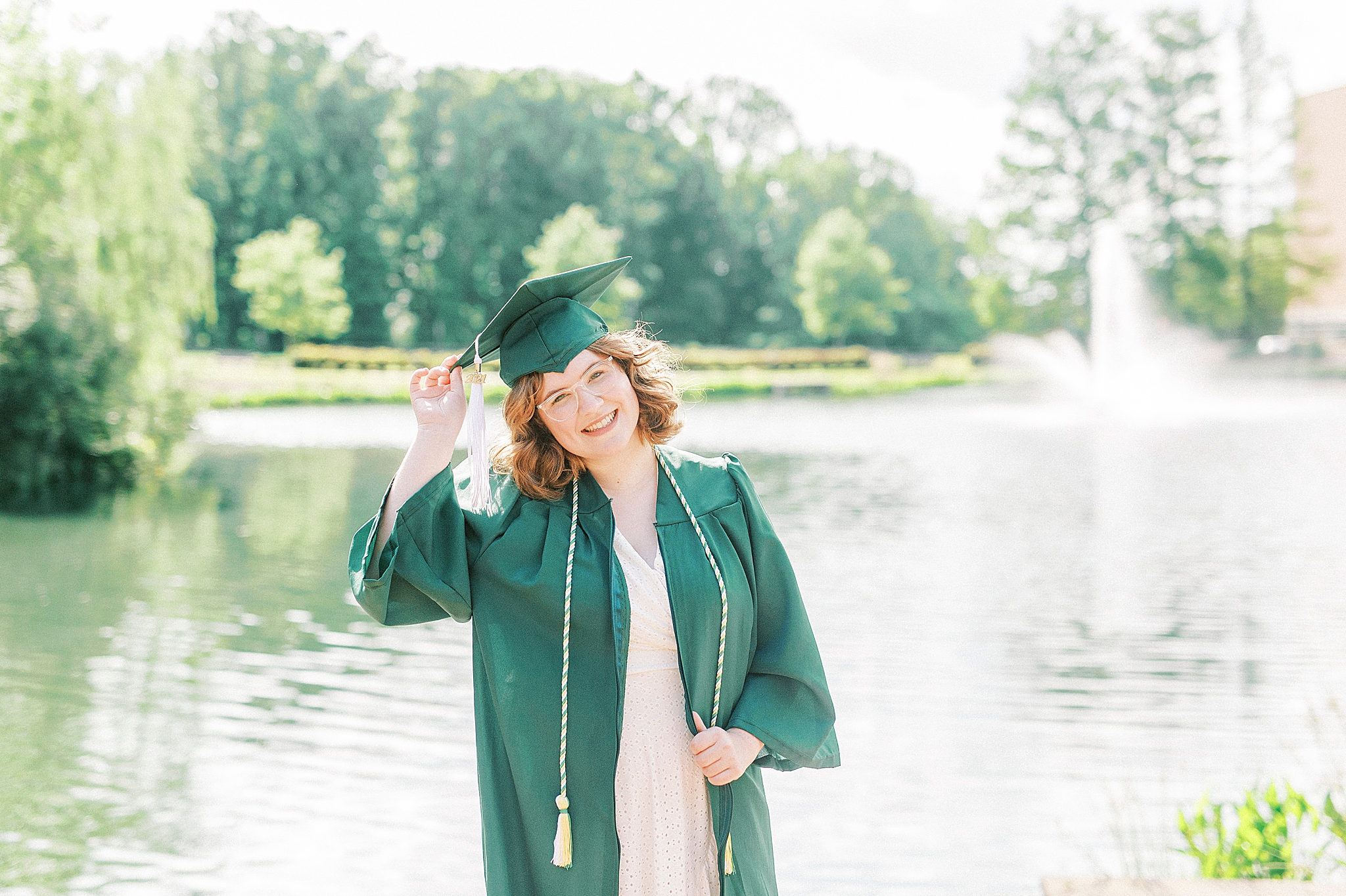senior tilts head posing during UNCC senior pictures