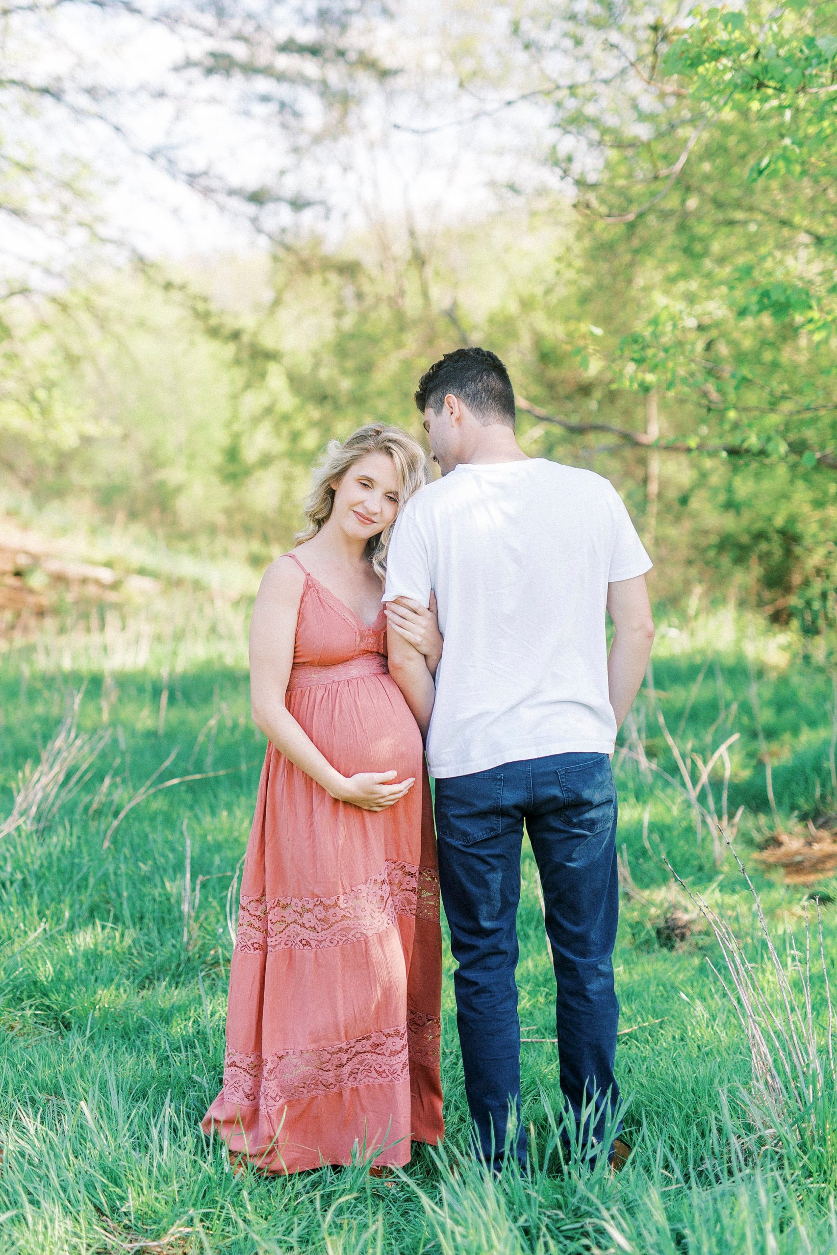 woman leans head on man's shoulder during Winston-Salem maternity photos