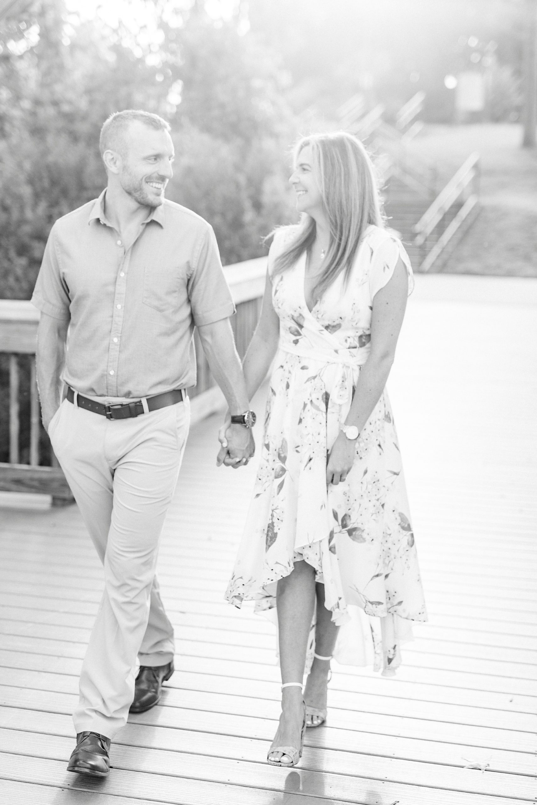 couple walks along wooden pier in Kevin Loftin Park