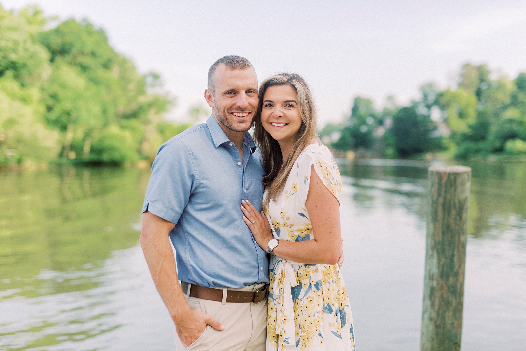 engaged couple stand in corner of pier at Kevin Loftin Park