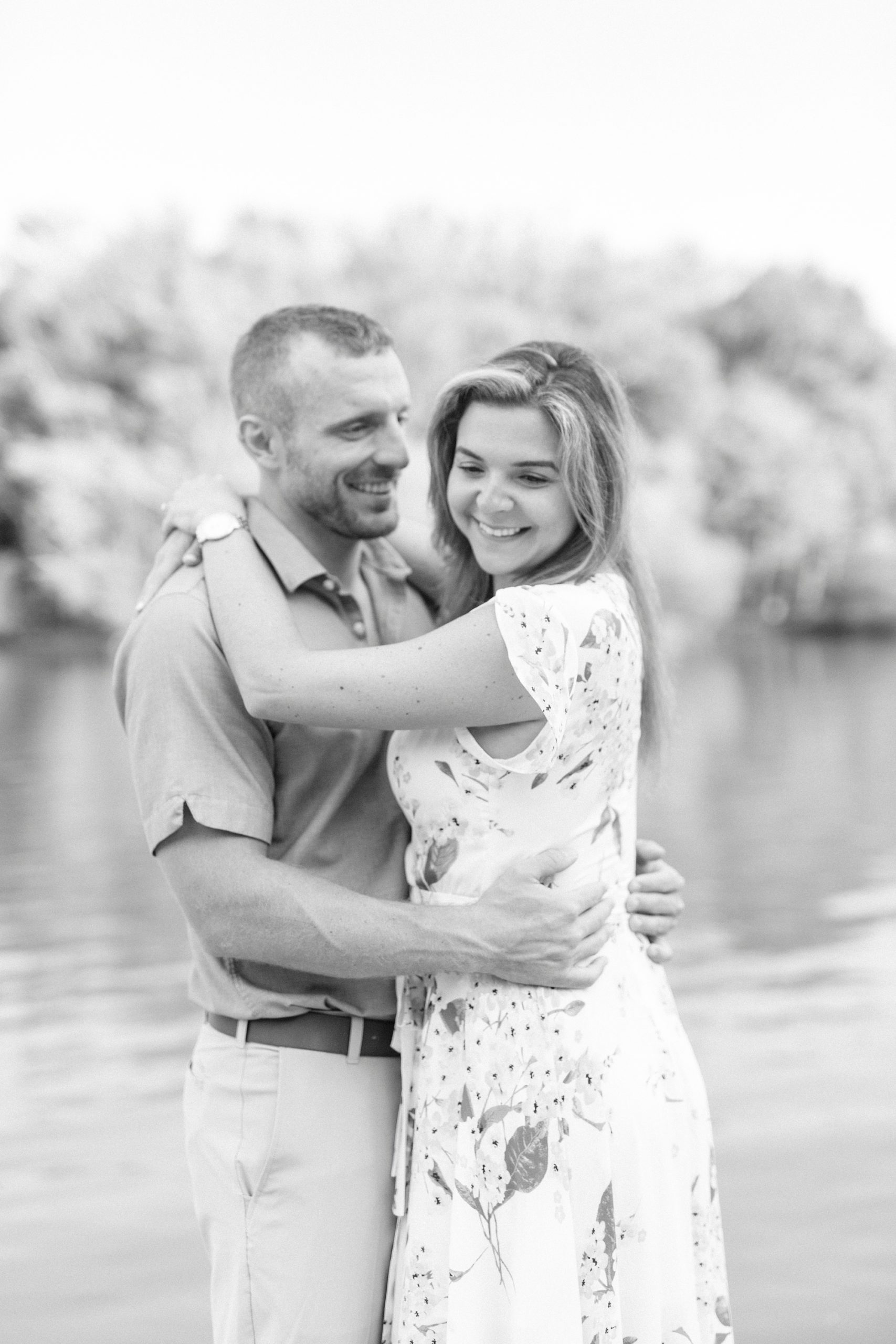 bride hugs groom around neck during Downtown Belmont engagement photos