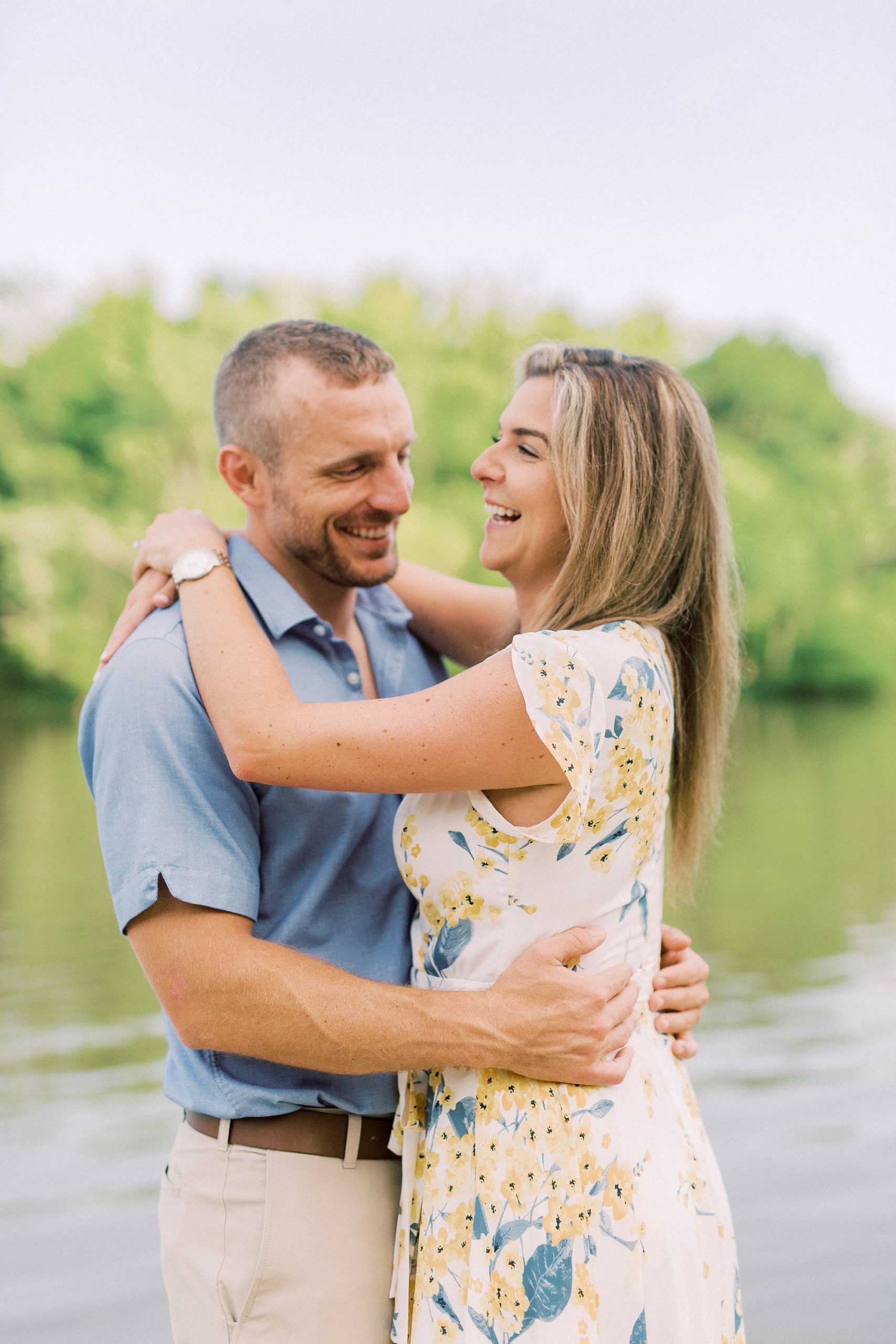 engaged couple laughs hugging in front of Catawba River