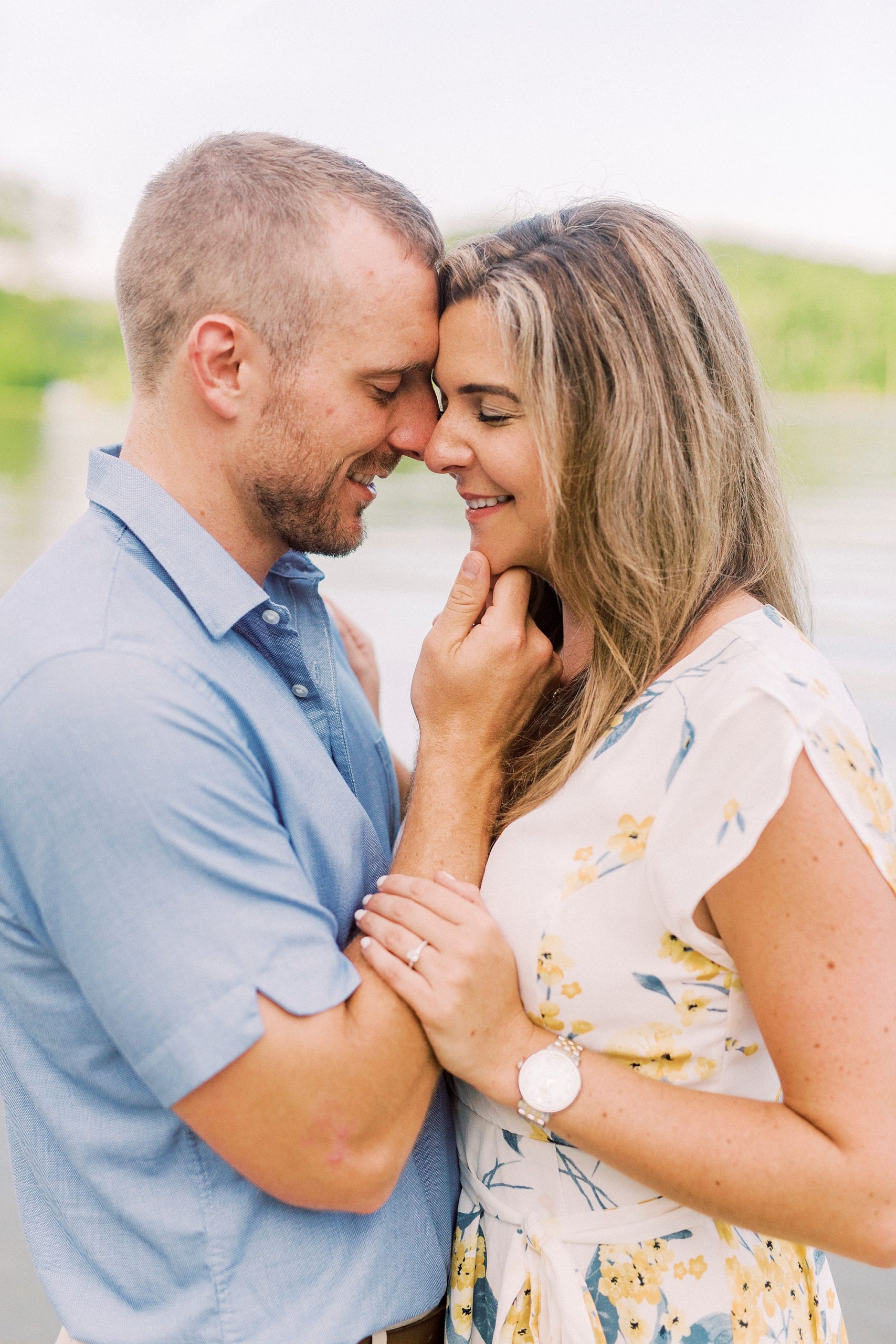 groom holds bride's chin during engagement photos