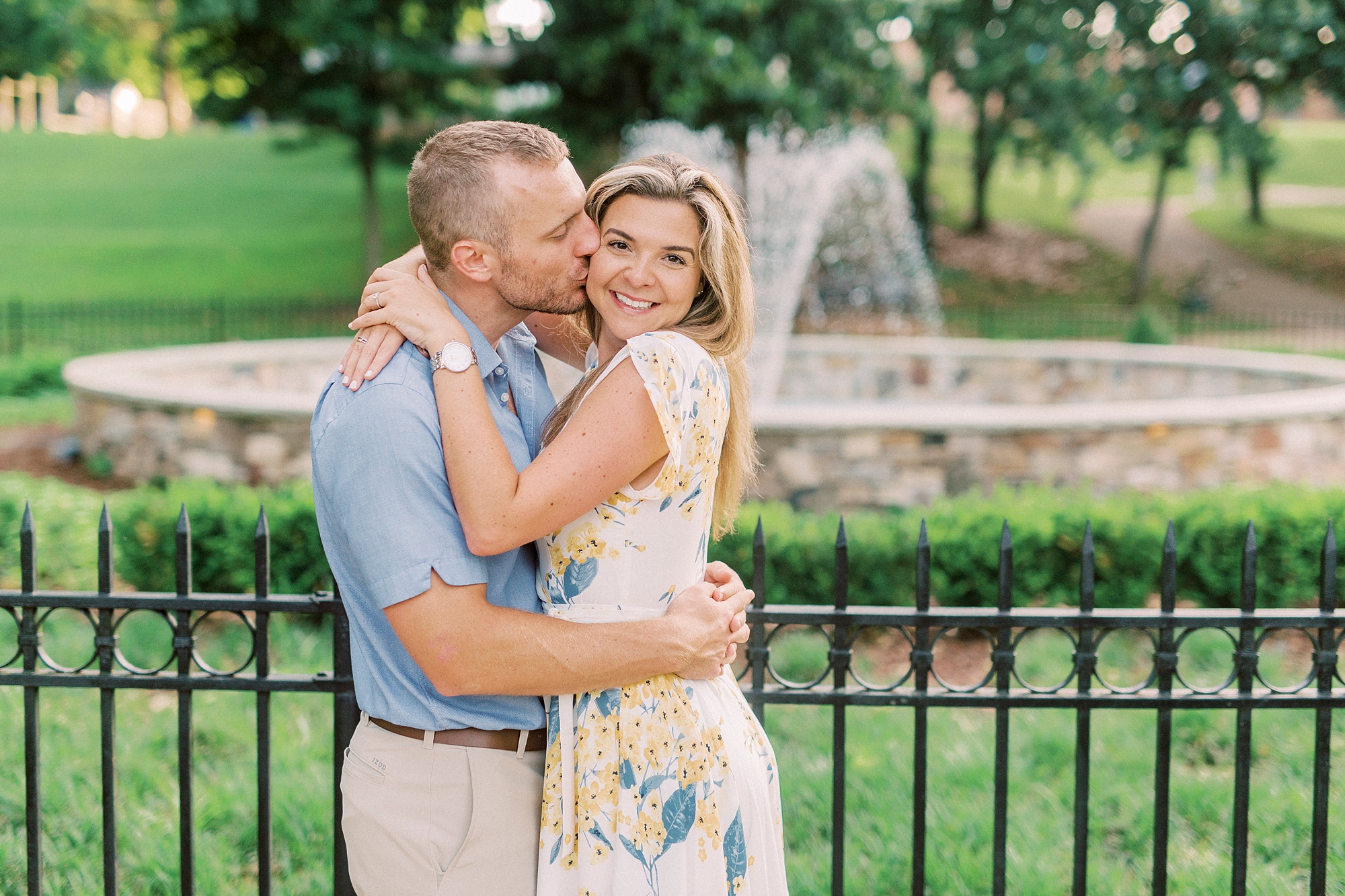bride and groom hug with groom kissing bride's cheek in Downtown Belmont park