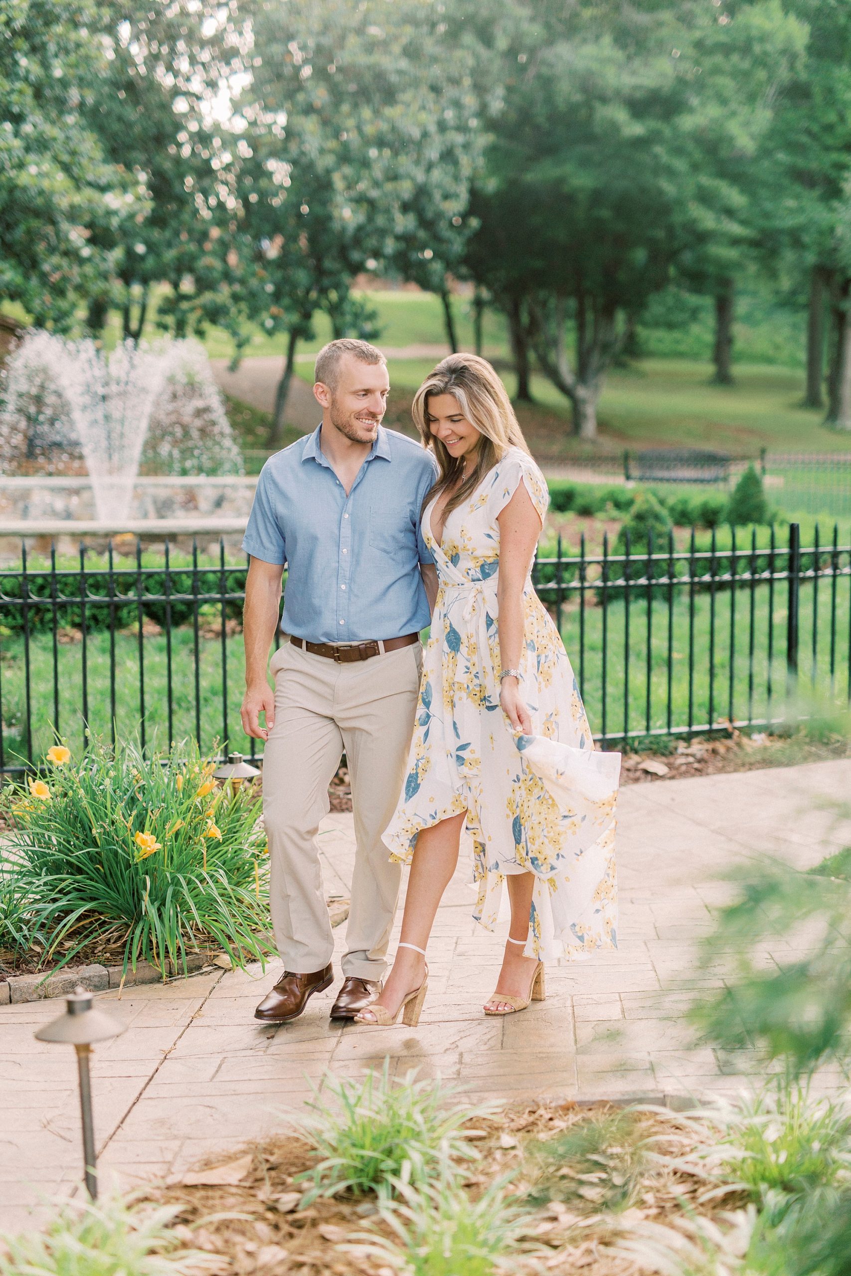 engaged couple walks through park