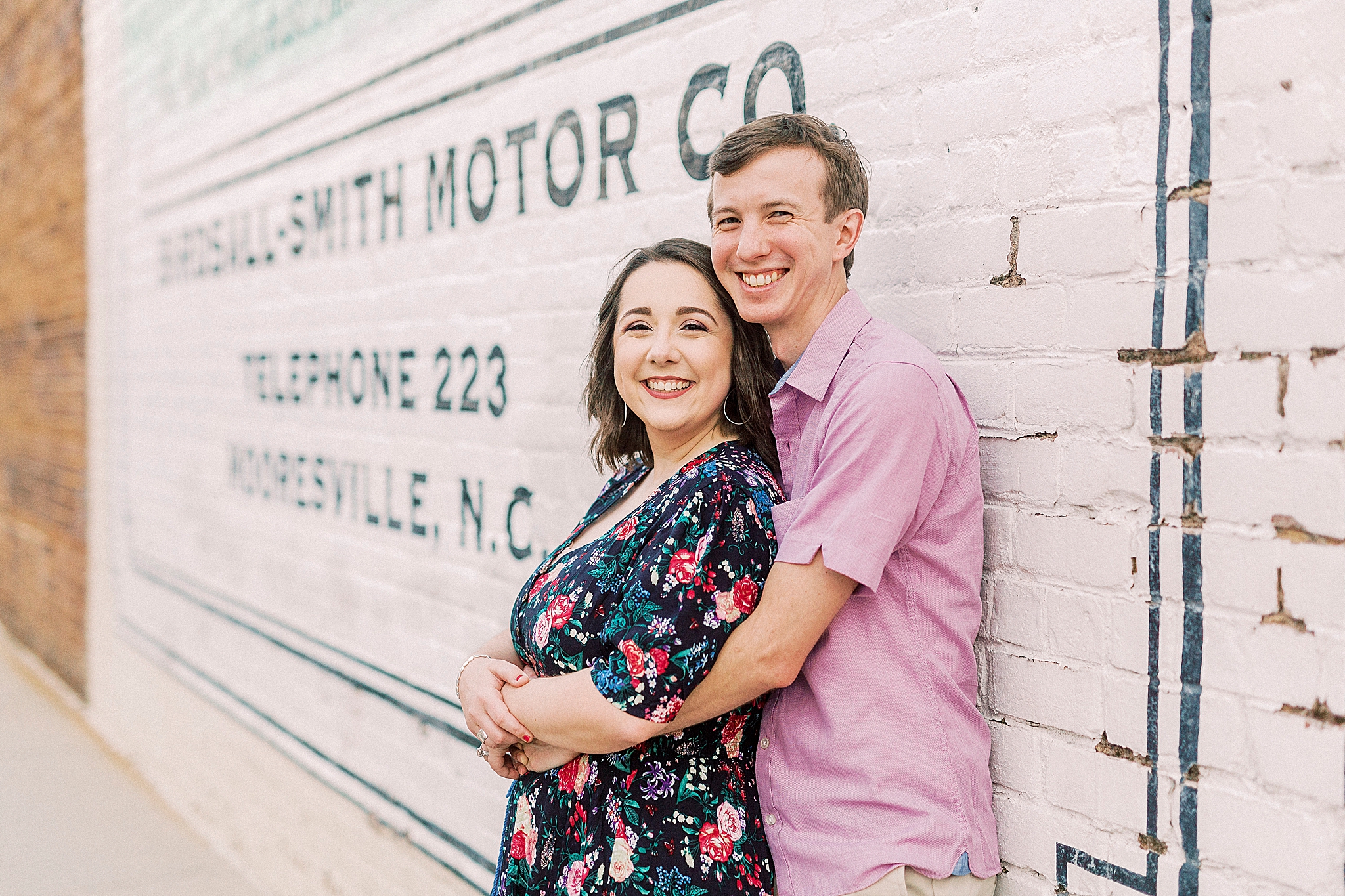 couple hugs by mural in downtown NC