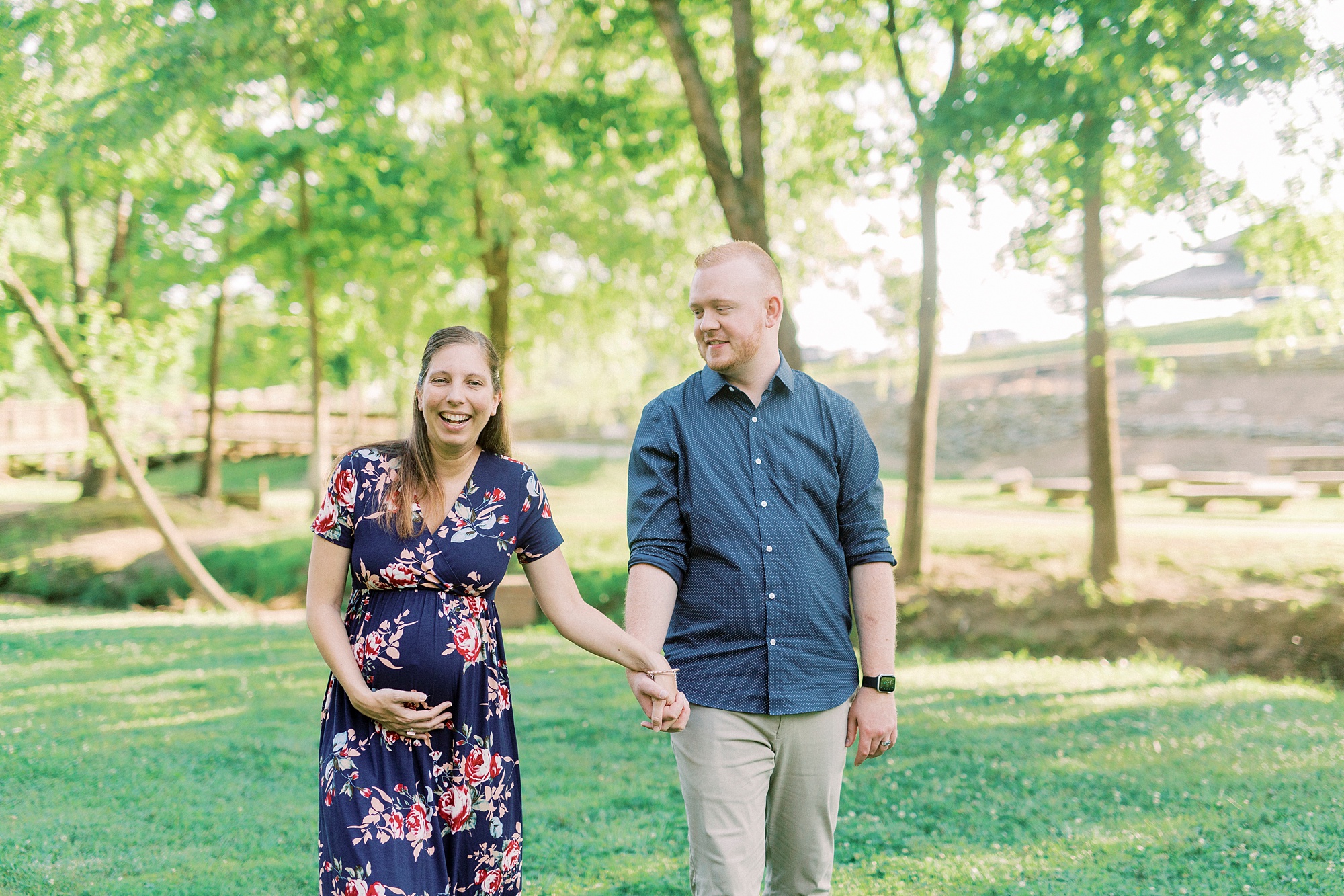 parents walk through Rankin Lake Park during maternity photos