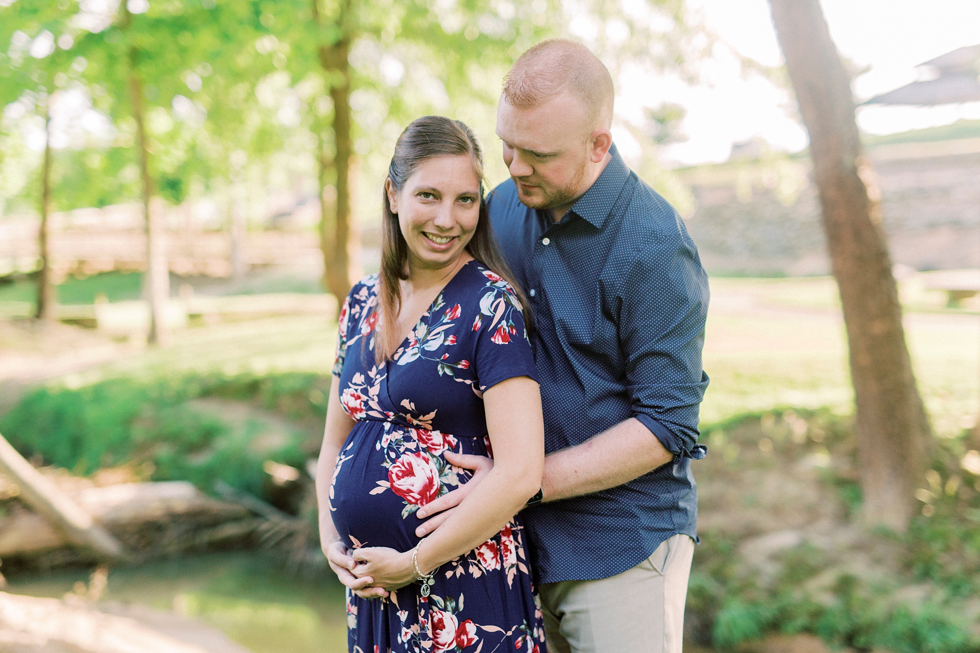 husband hugs wife from behind during Rankin Lake Park maternity session