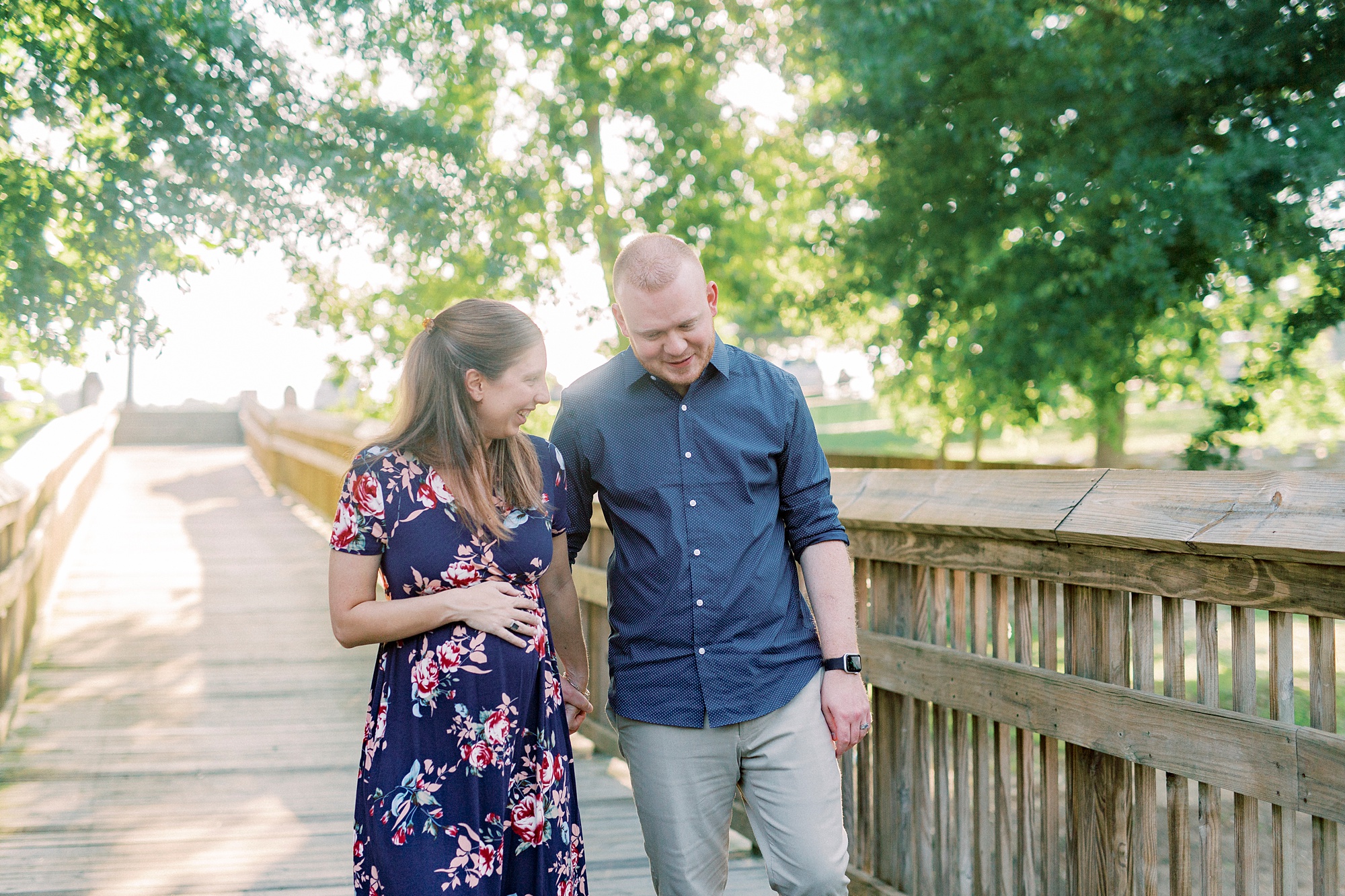 husband and wife walk on wooden bridge in Gastonia NC