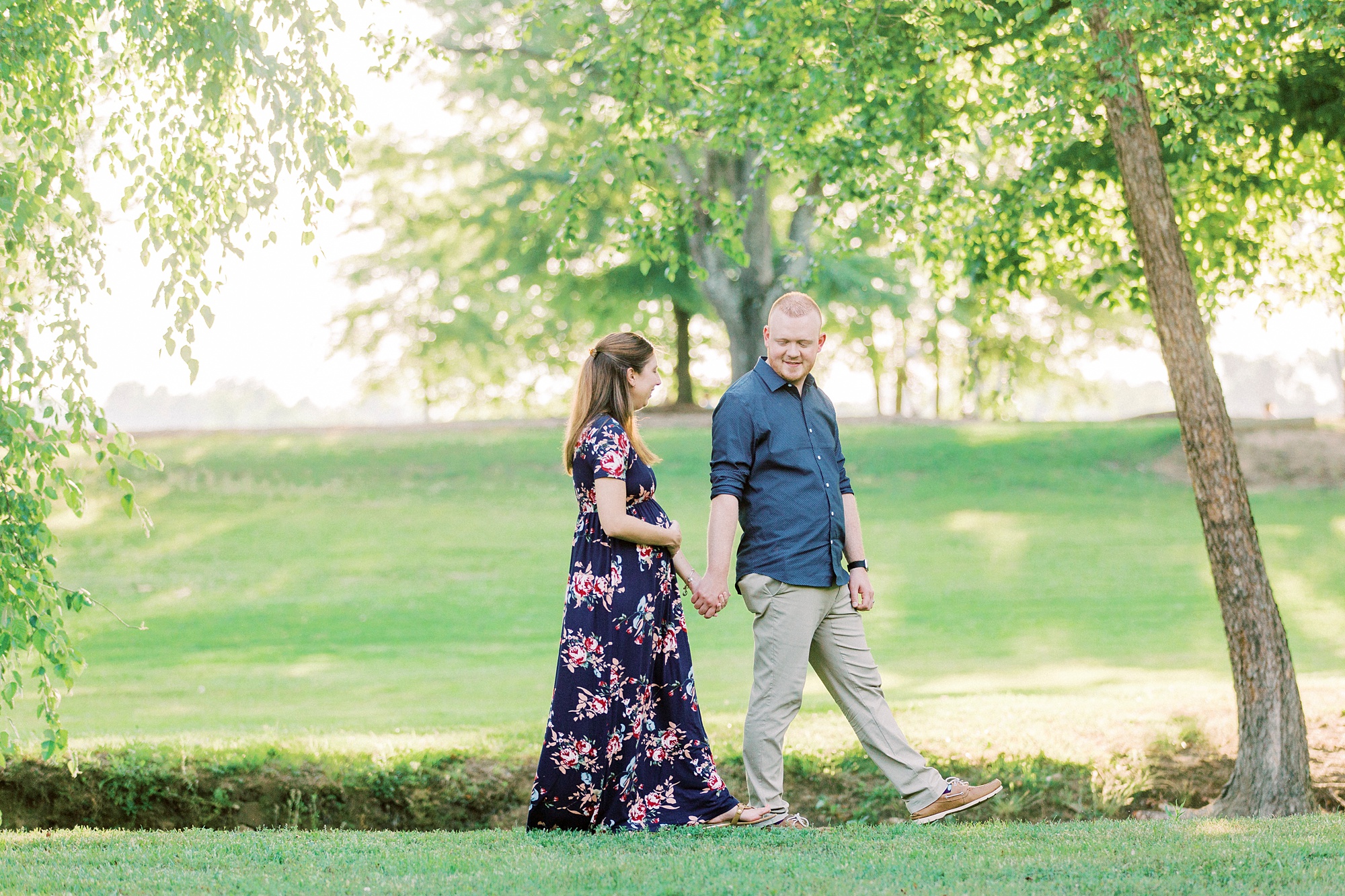 expecting parents walk along waterfront at Rankin Lake Park