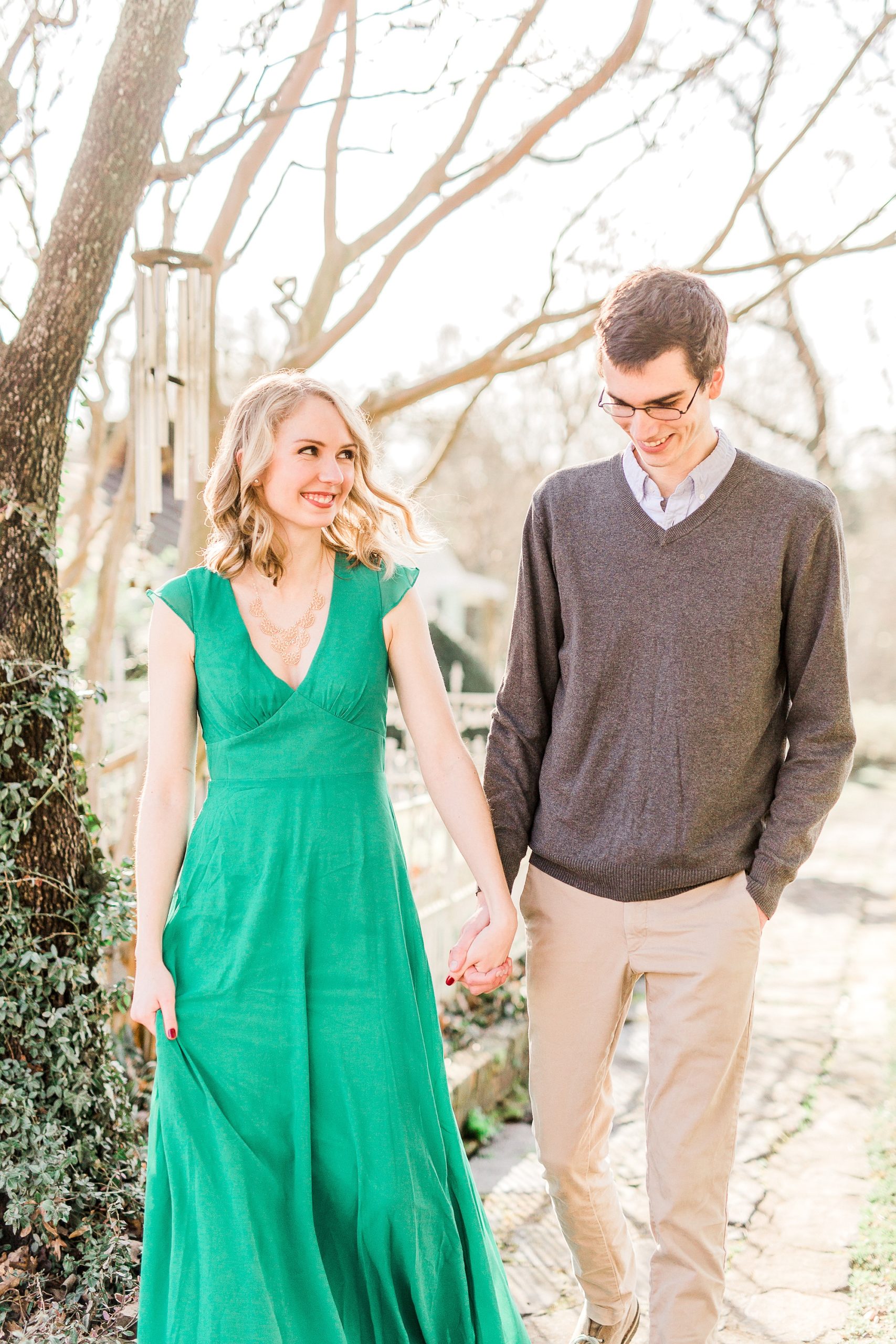 bride and groom hold hands walking through field at the 1812 Hitching Post