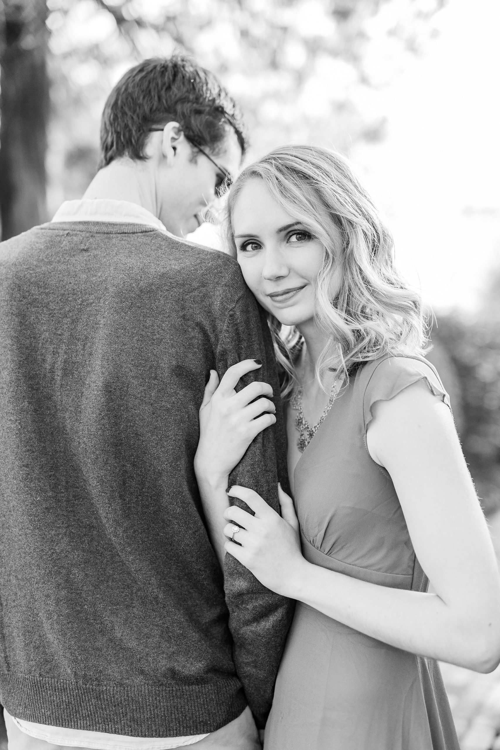 bride leans against groom's arm during winter engagement session at the 1812 Hitching Post