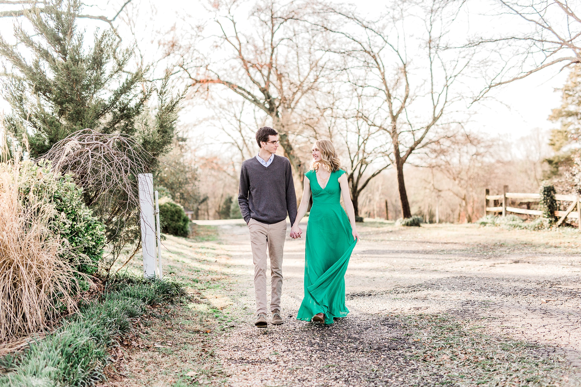 bride moves green dress while walking on path at the 1812 Hitching Post
