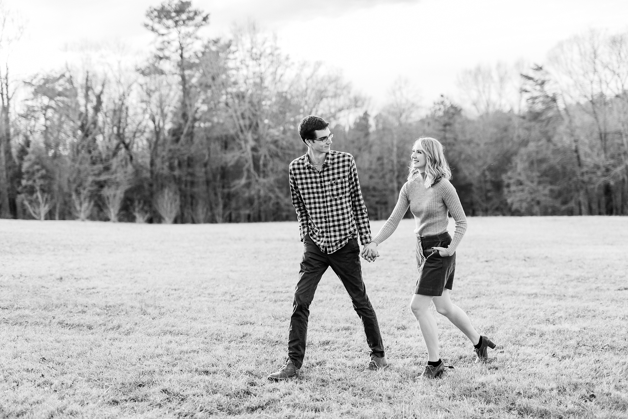 engaged couple walks through field in NC