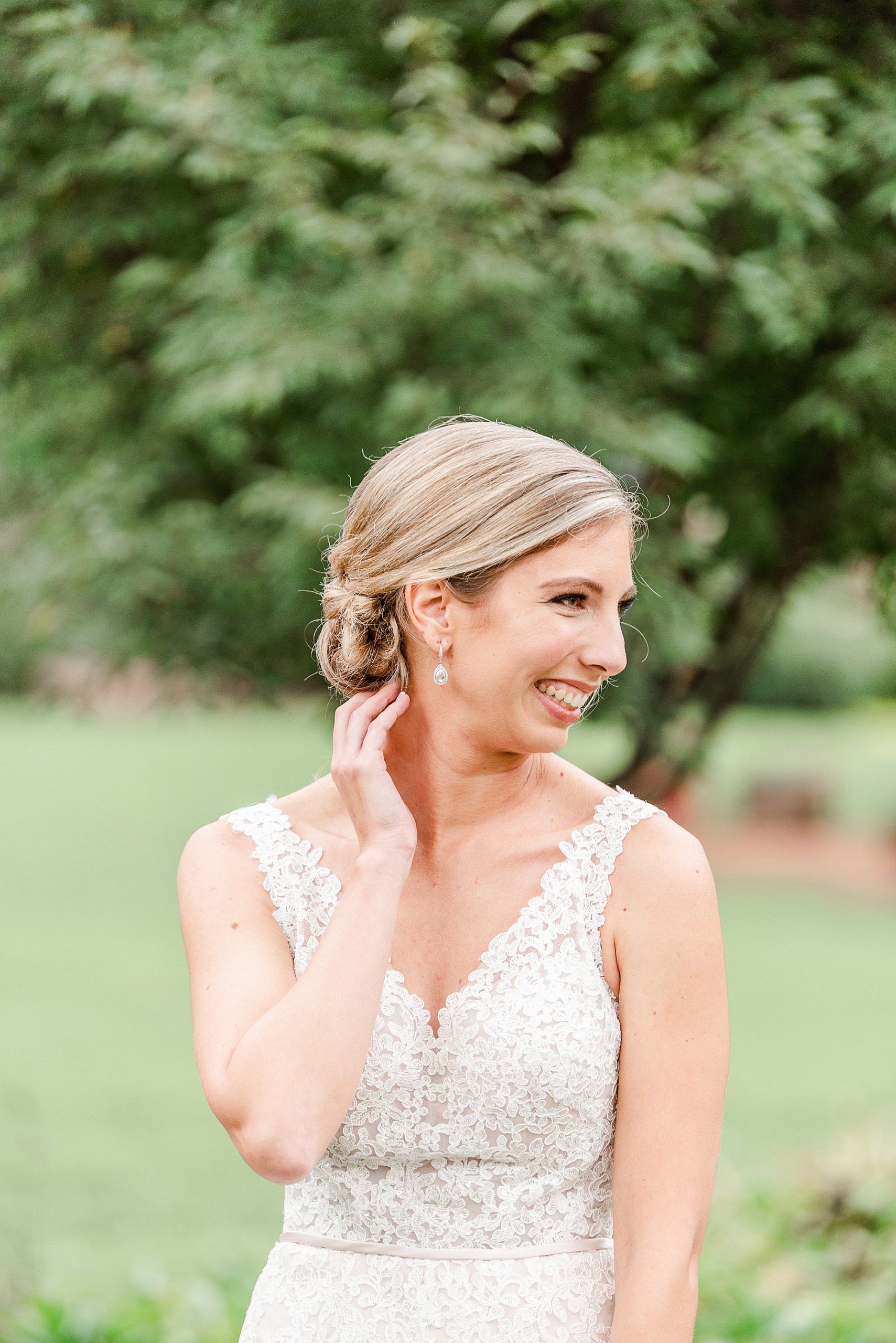 bride looks over shoulder laughing during portraits at Alexander Homestead