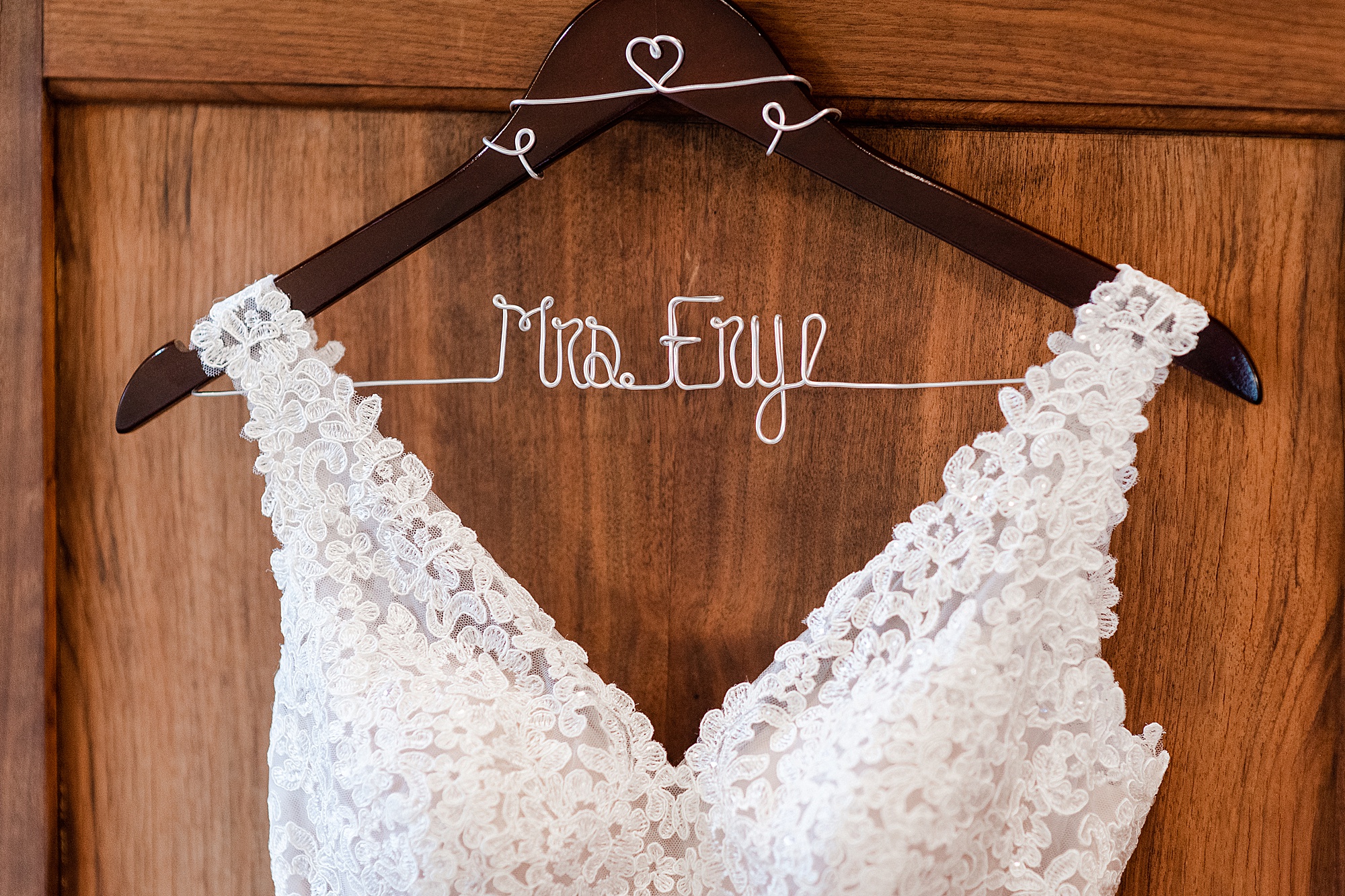 wedding dress hangs on wooden door