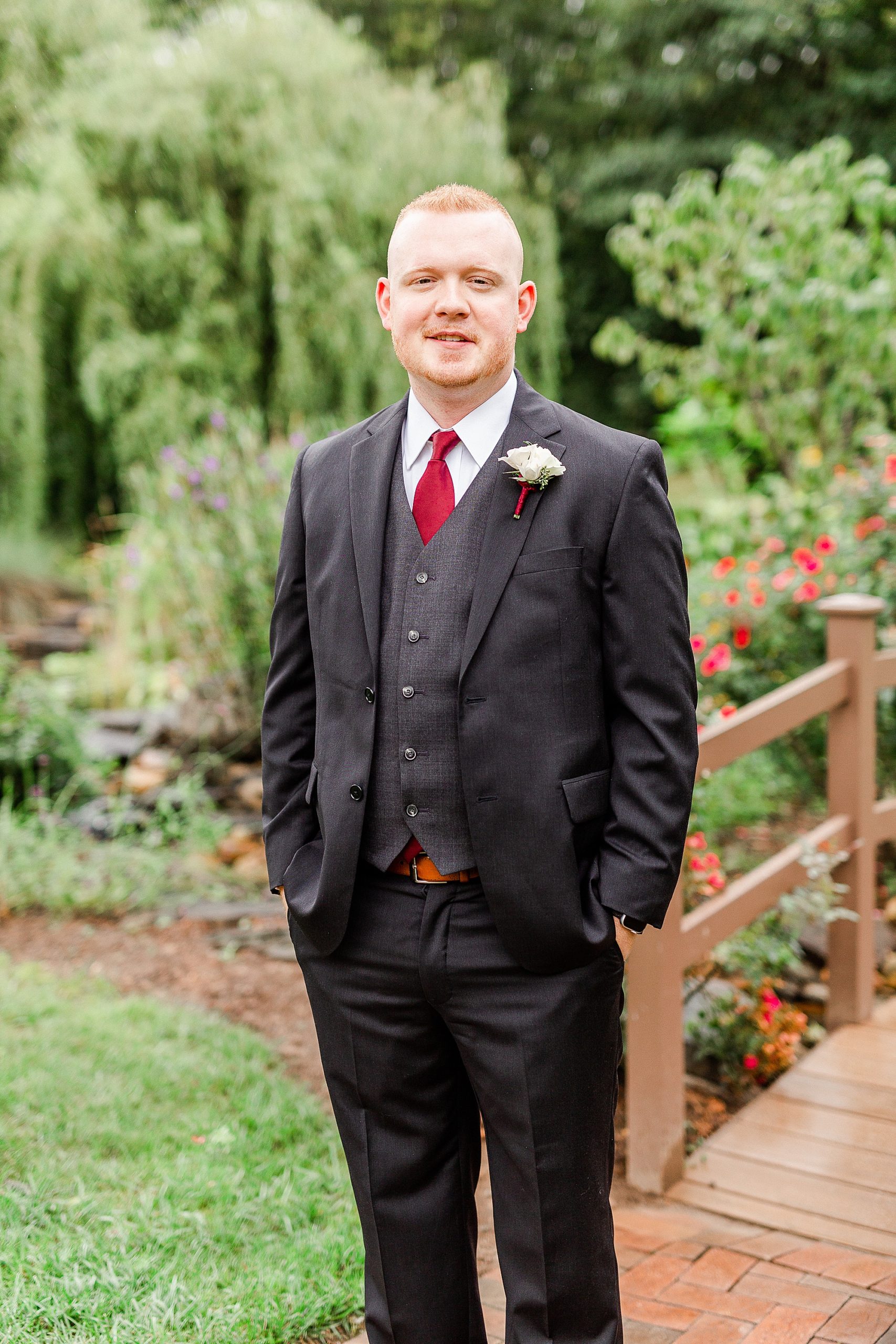 portraits of groom by wooden bridge