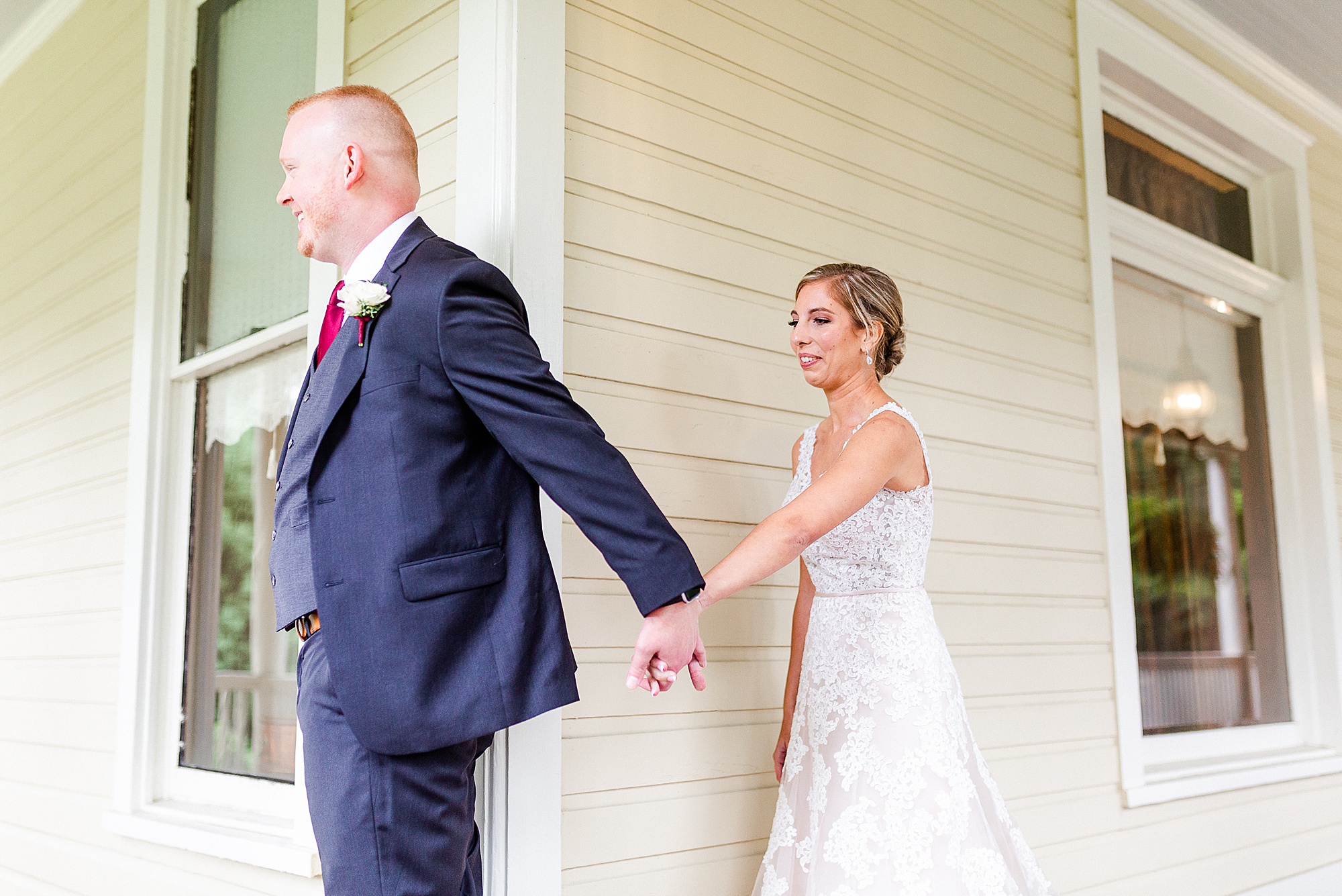 bride and groom have first touch on porch at Alexander Homestead