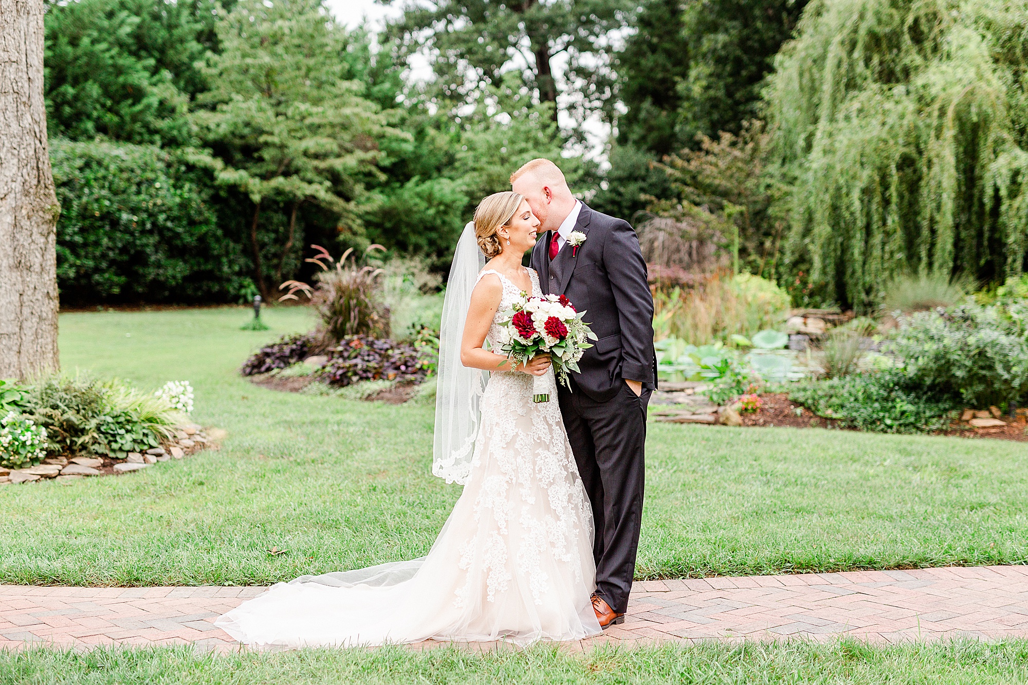 bride and groom pose in gardens at Alexander Homestead