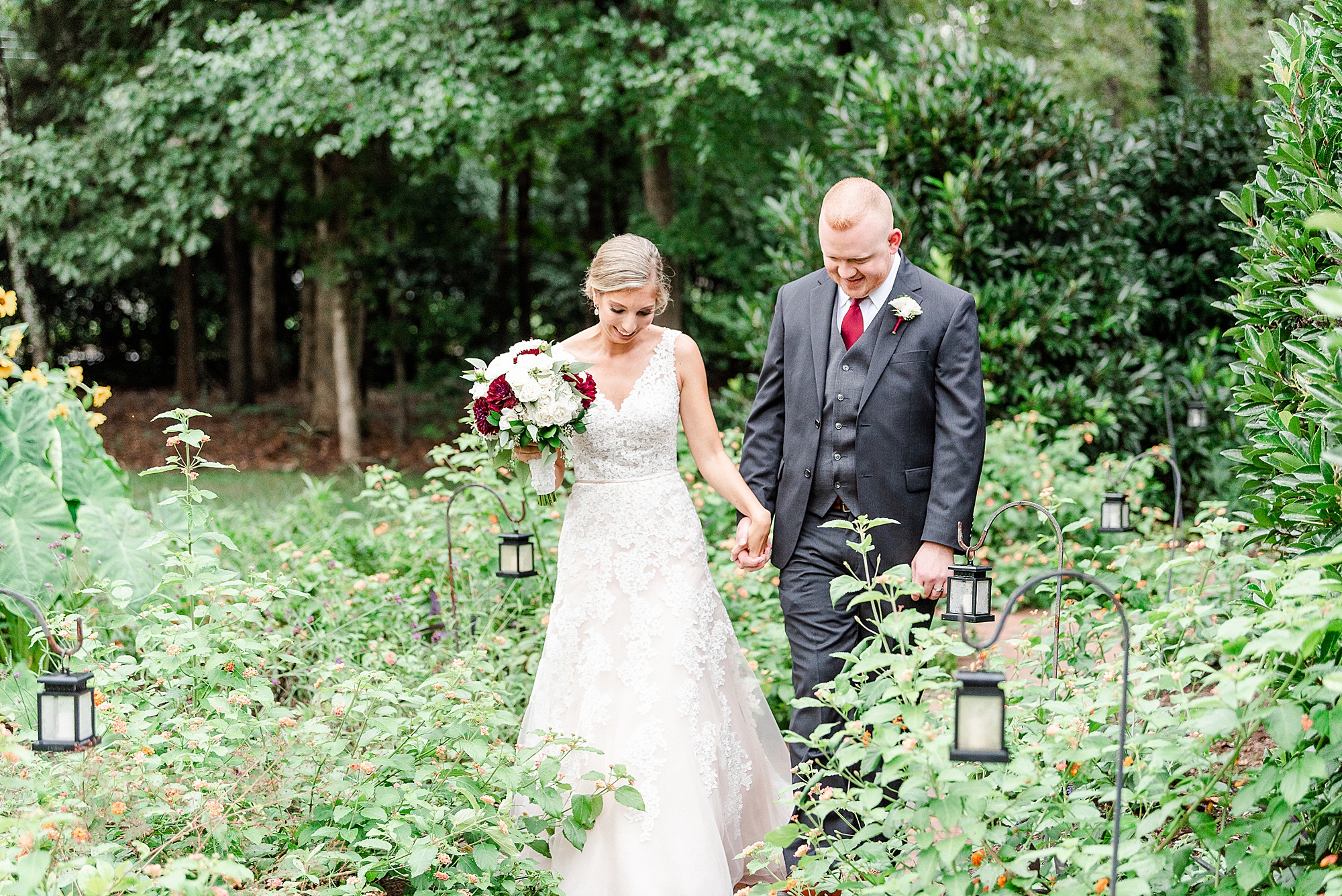 bride and groom walk through gardens in Charlotte NC