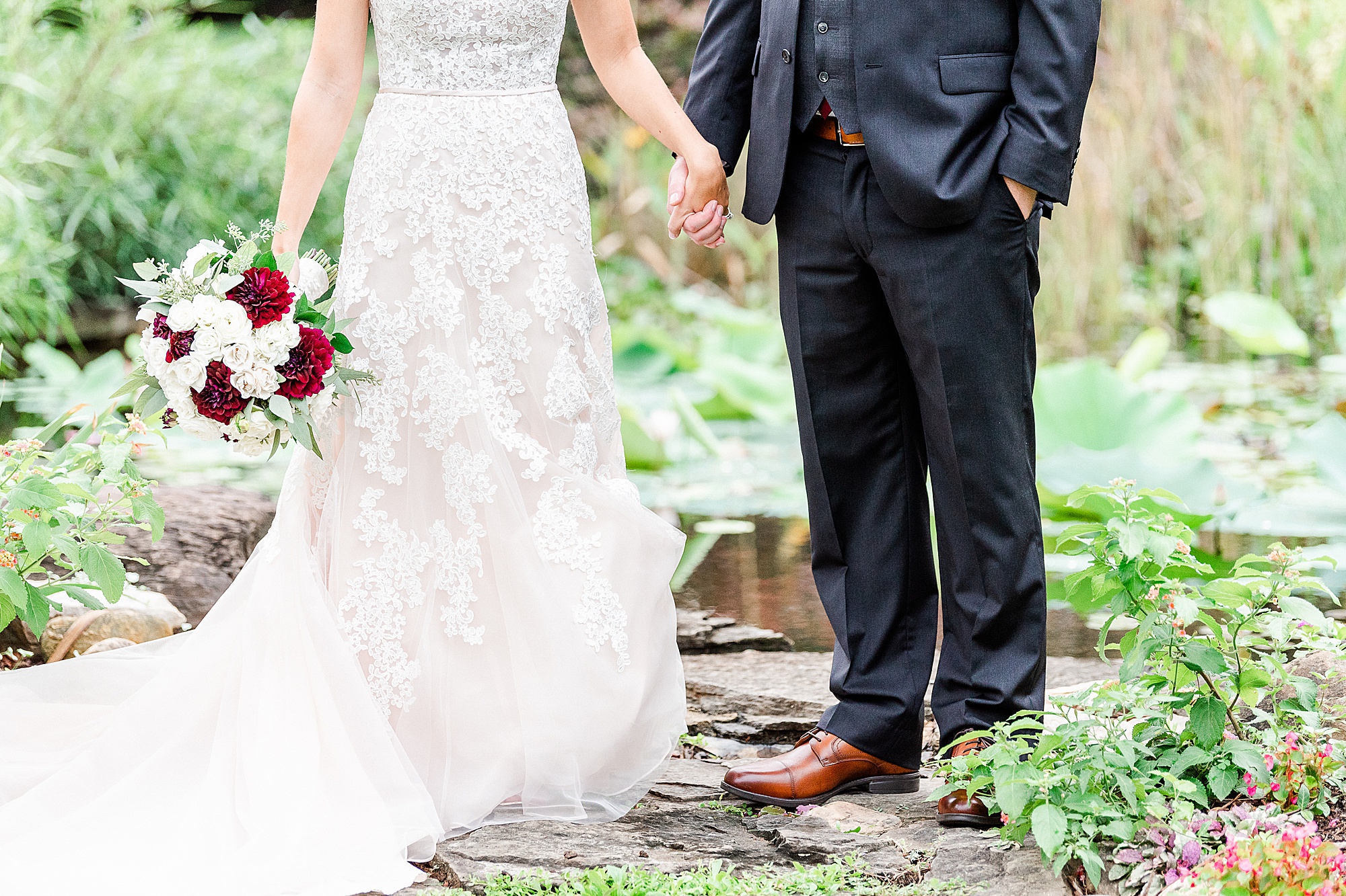 bride and groom hold hands standing on rocks at Alexander Homestead