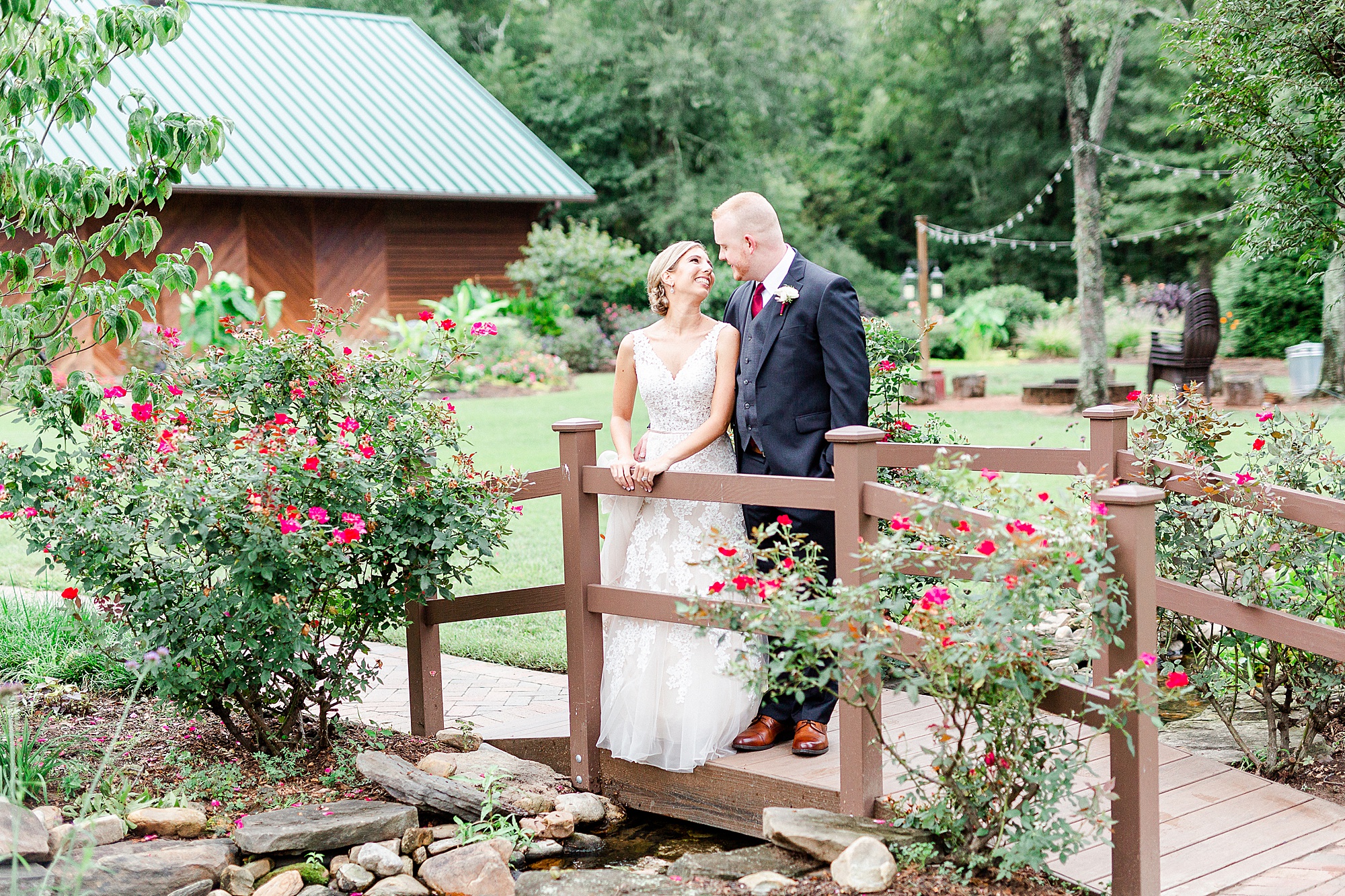 newlyweds kiss on wooden bridge in Alexander Homestead