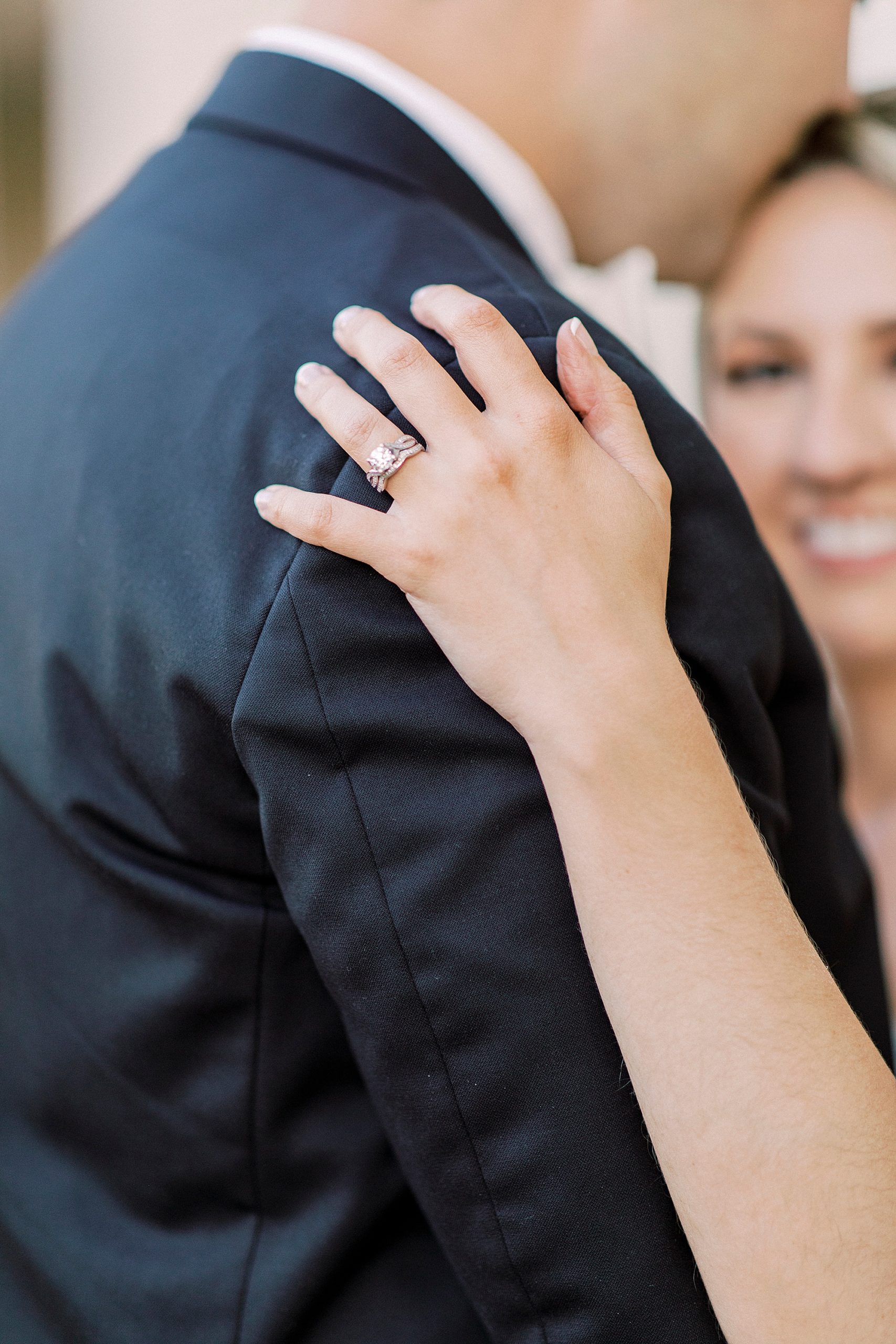 bride holds groom's arm during elegant Charlotte wedding photos